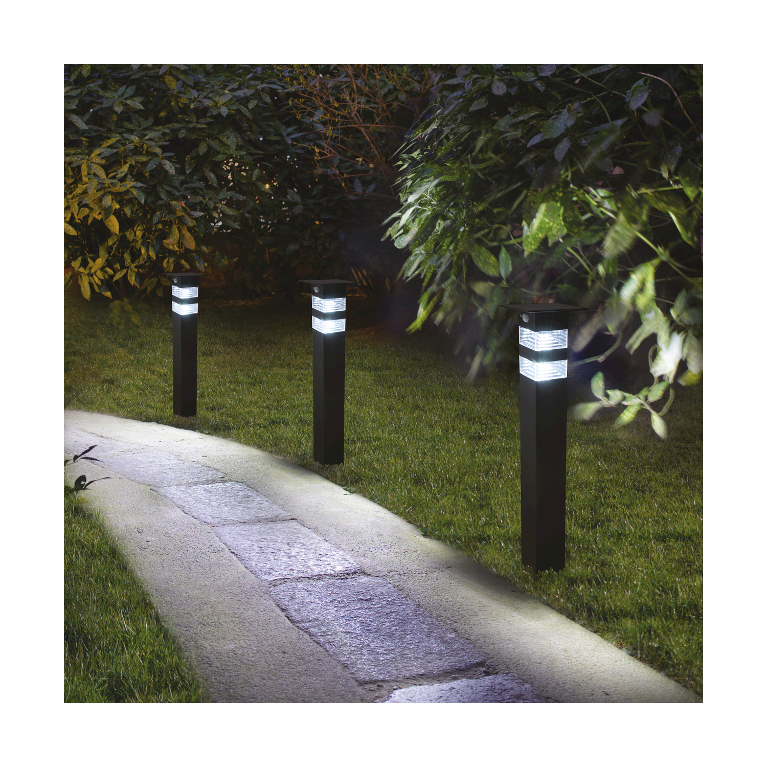 Sentiero con tre luci nere, illuminato dalle luci, in un giardino.