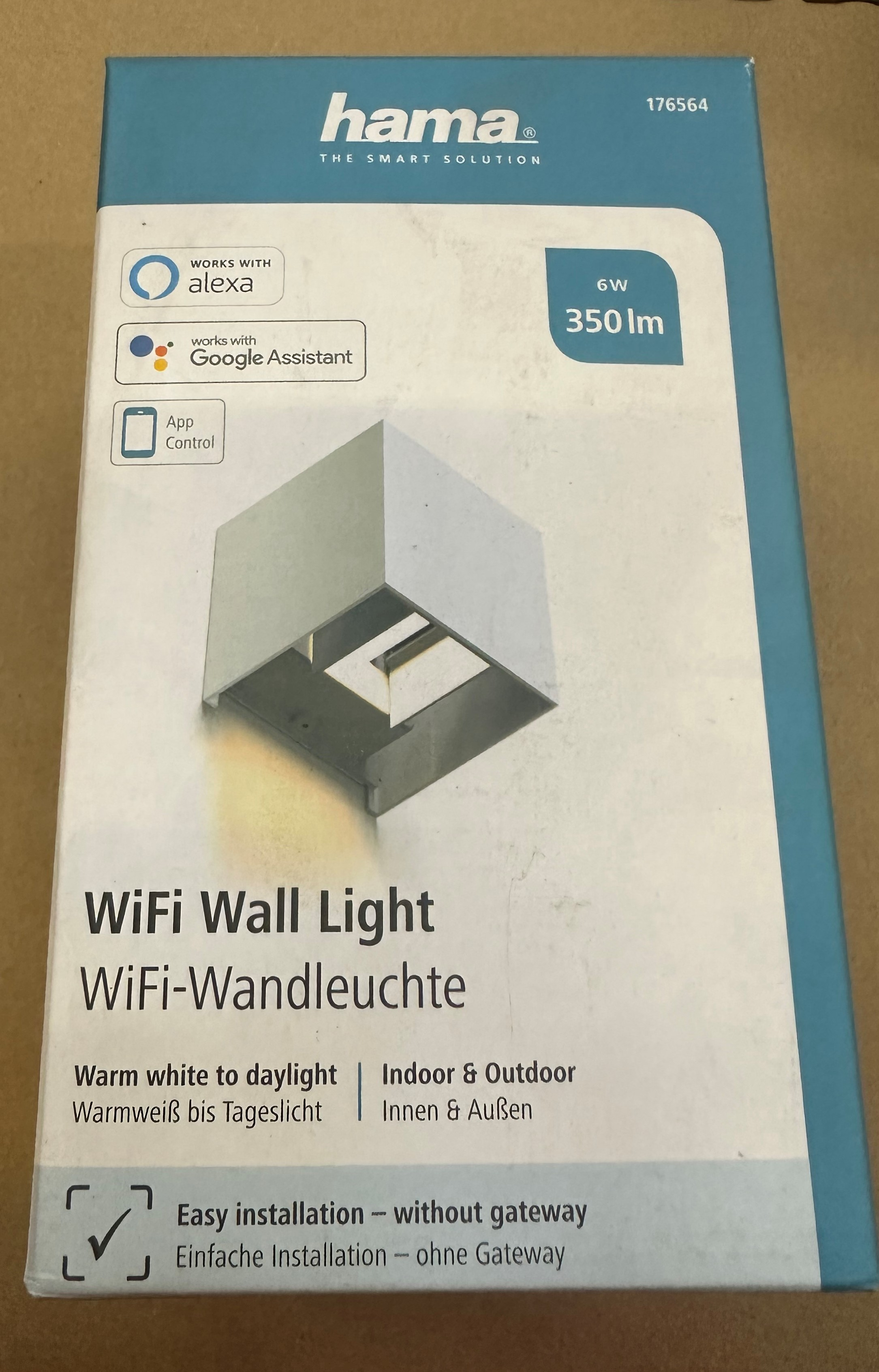 Niebiesko-białe pudełko do lampy ściennej Hama WiFi. Tekst zawiera logo Alexa i Google Assistant.