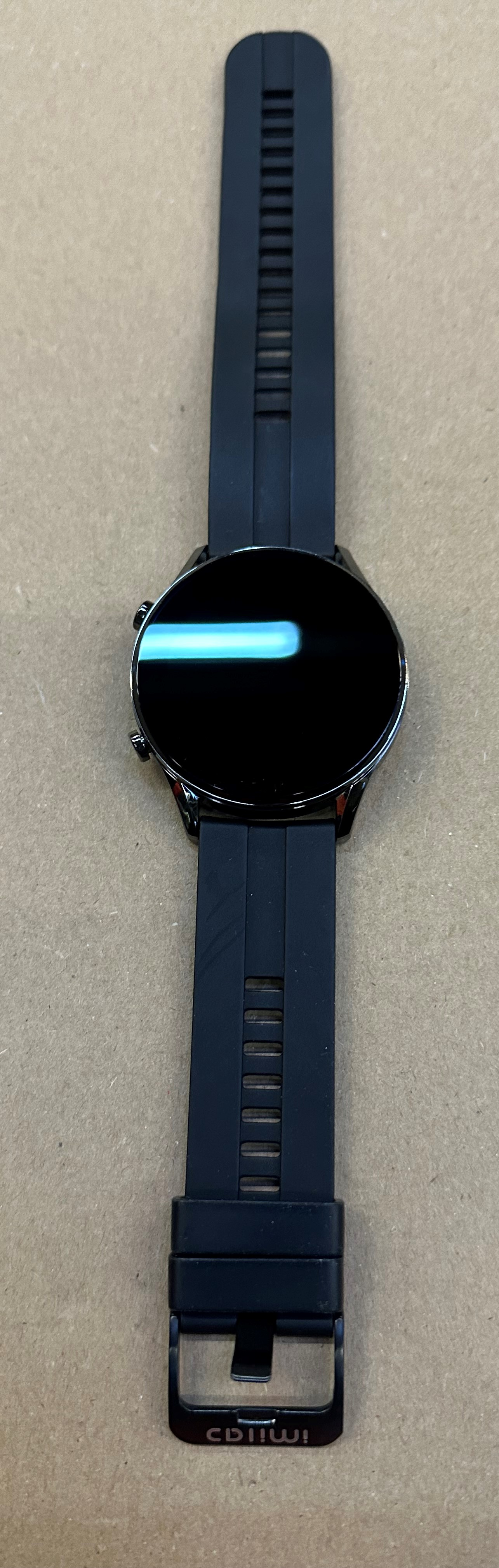 Czarny smartwatch z czarnym paskiem, widok z góry.