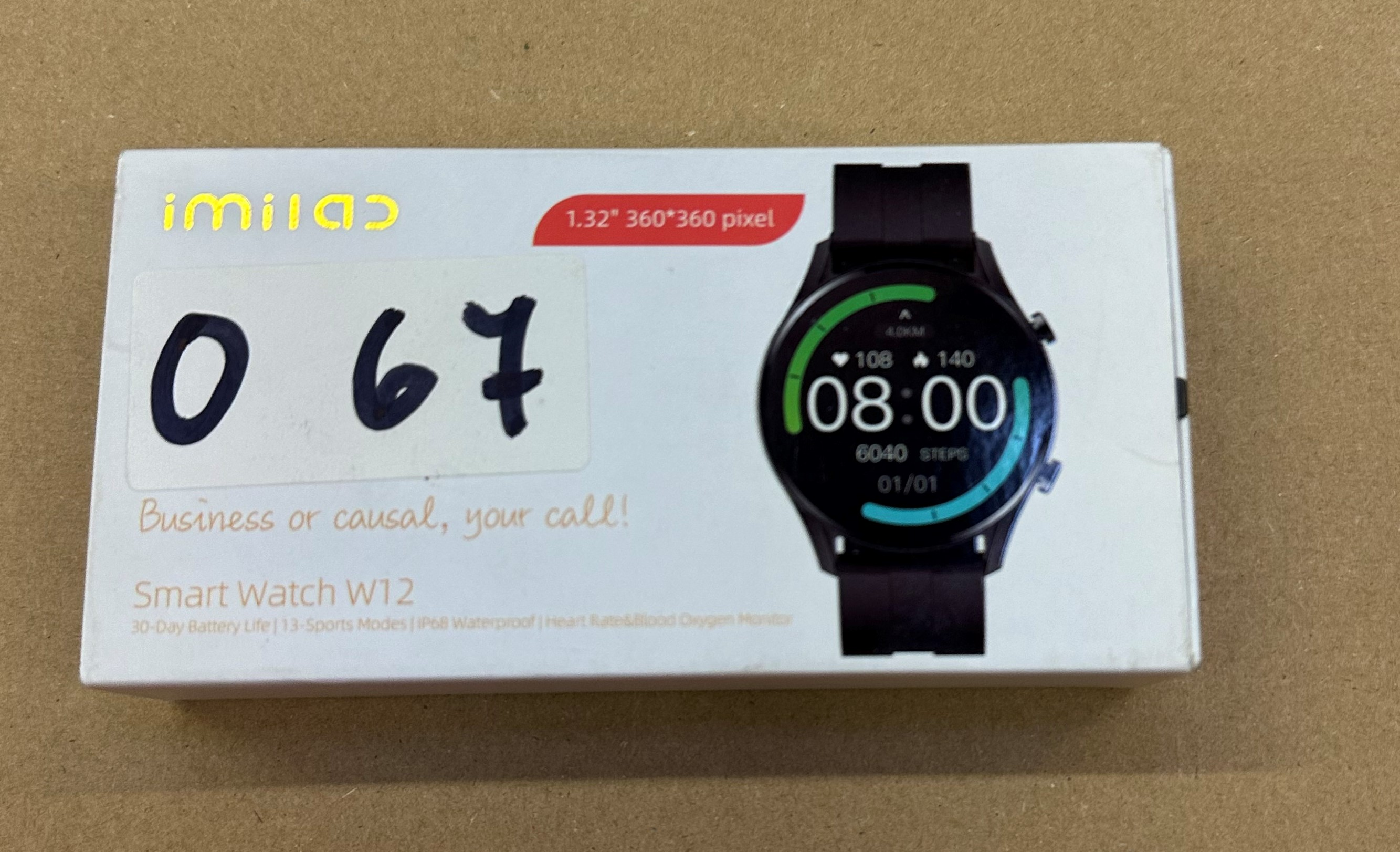 Pudełko smartwatch z zegarkiem pokazującym czas i dane zdrowotne. Na pudełku liczby 067.