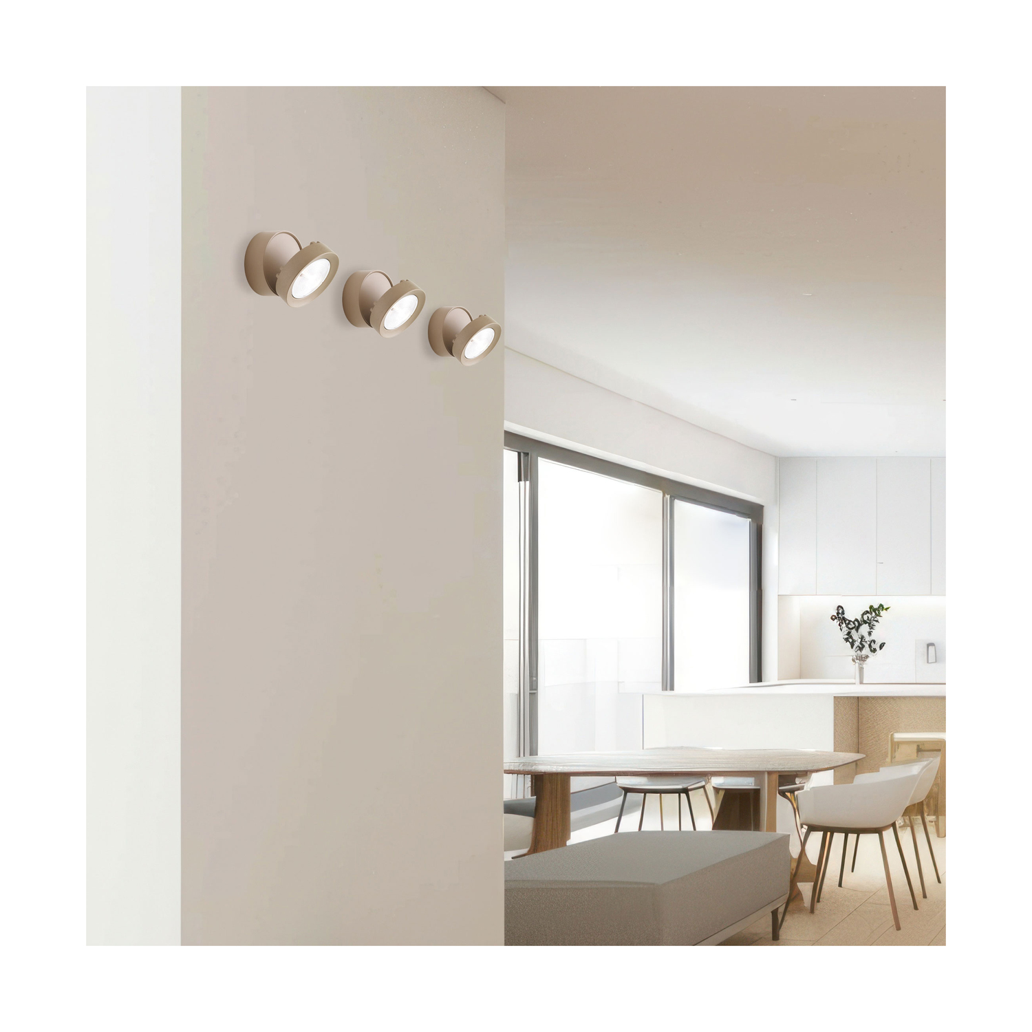 Cinque faretti montati su una parete beige, rivolti verso il basso. Soffitto e tavolo bianchi visibili.
