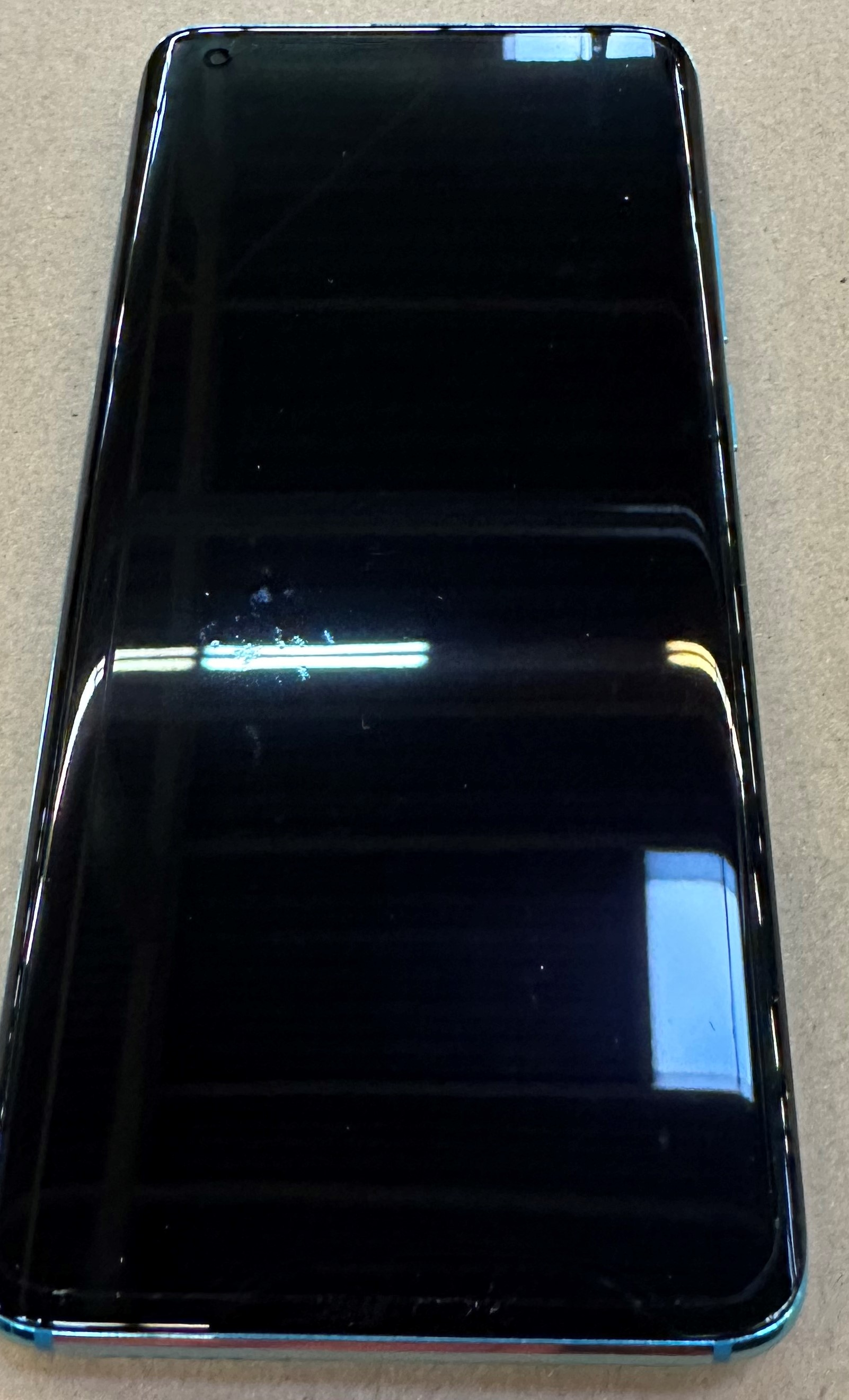 Czarny ekran smartfona z niebieską ramką, pokazujący pusty, ciemny wyświetlacz.