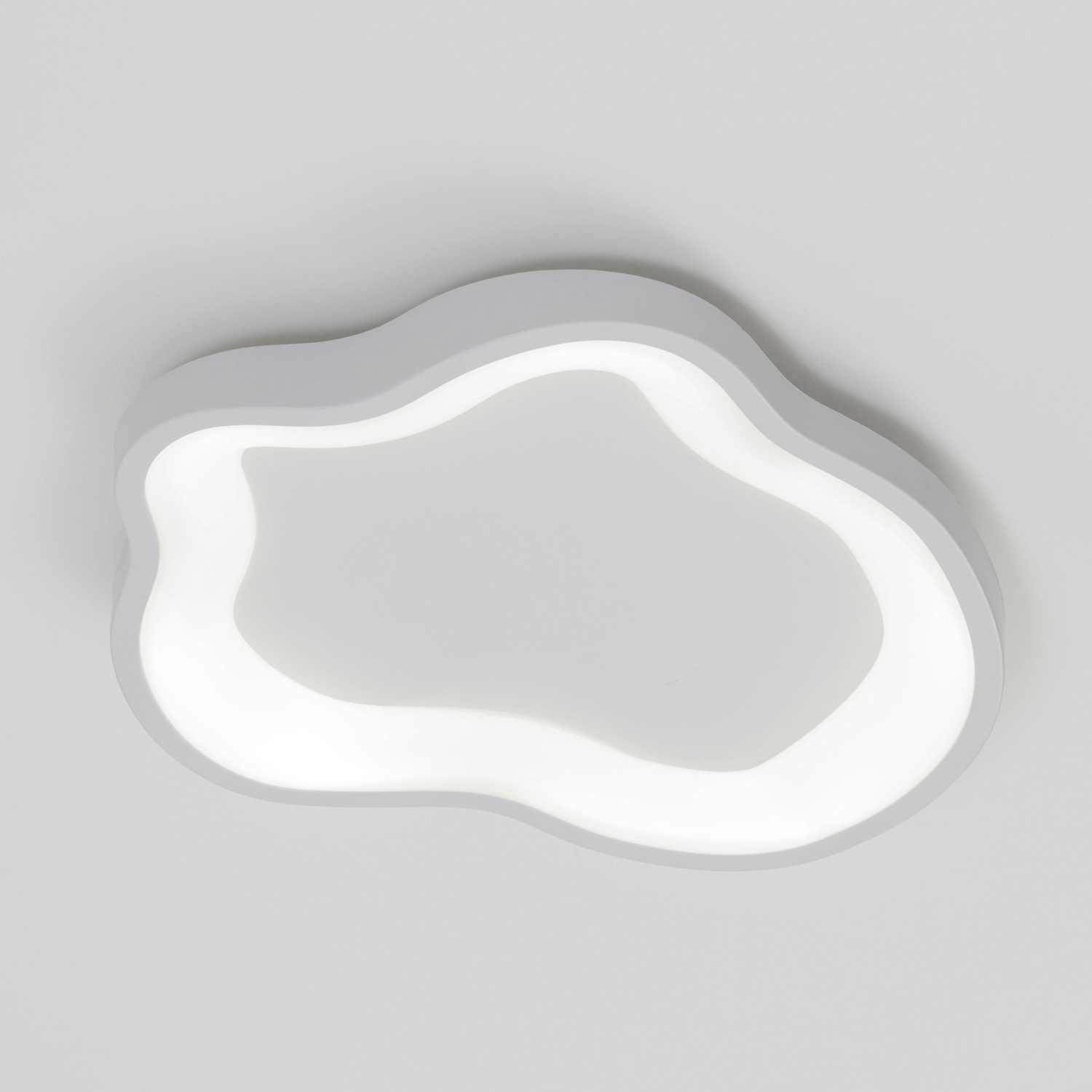 Un apparecchio per illuminazione a soffitto bianco a forma di nuvola con una luminosa lucentezza interna.
