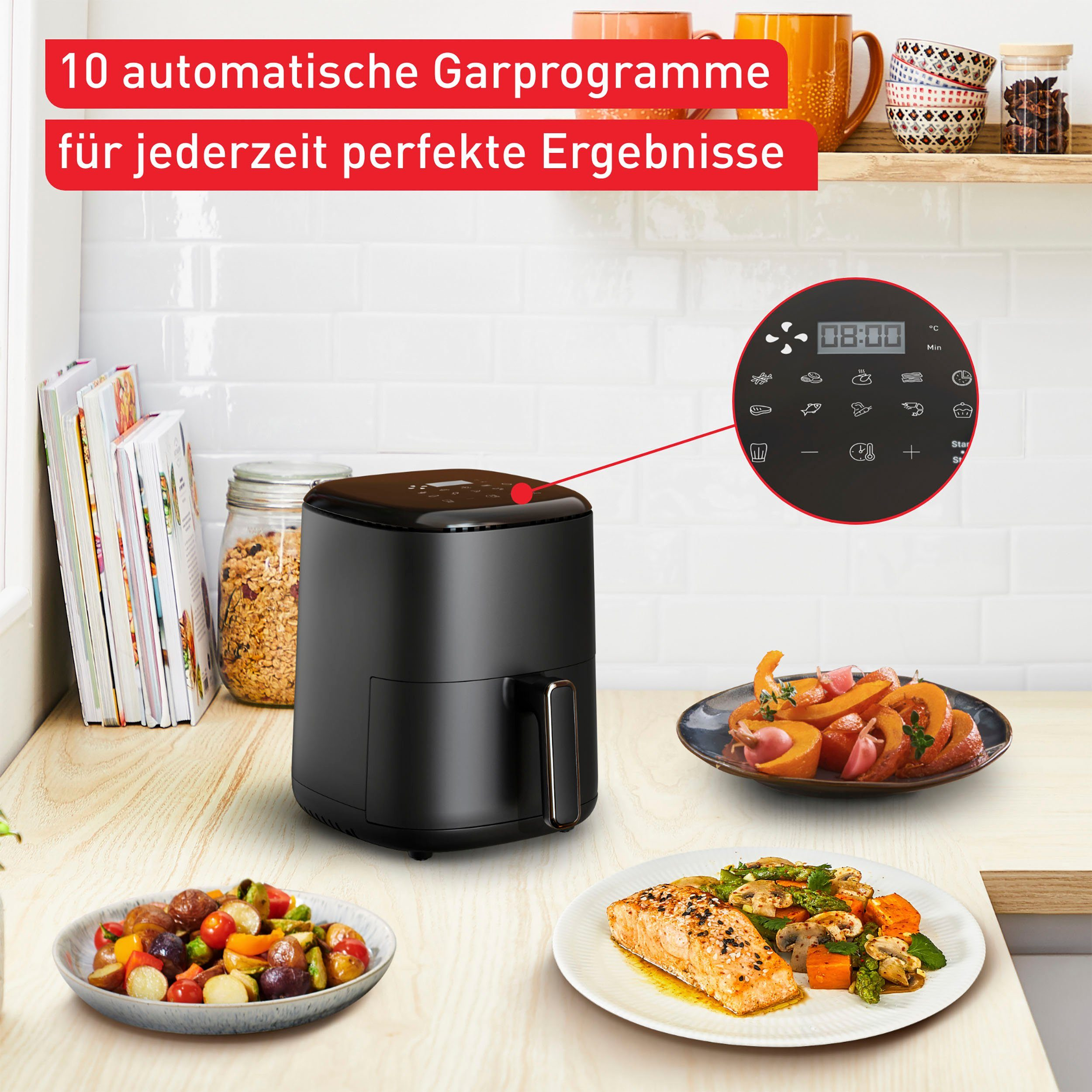 Schwarze Heißluftfritteuse mit Bedienfeld und verschiedenen gekochten Gerichten auf einem Tisch.
