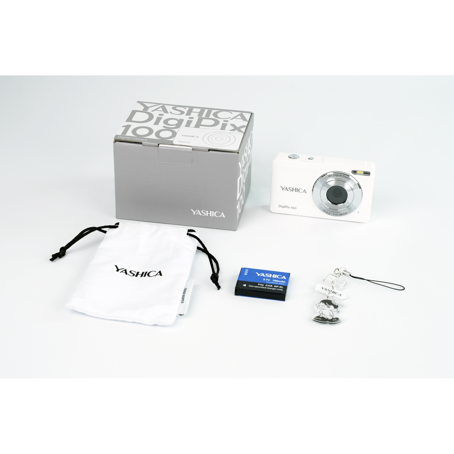 Witte Yashica DigiPix 100 camera, doos, tas, batterij en accessoires op witte achtergrond.