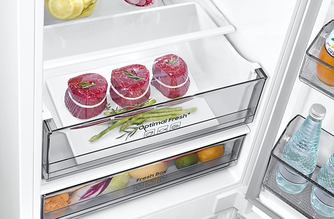 Wnętrze lodówki ze świeżą żywnością: steki, warzywa i napoje.