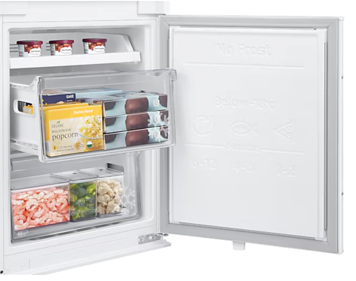 Wnętrze białej lodówki z przechowywanymi w niej przedmiotami. Są pojemniki z żywnością.