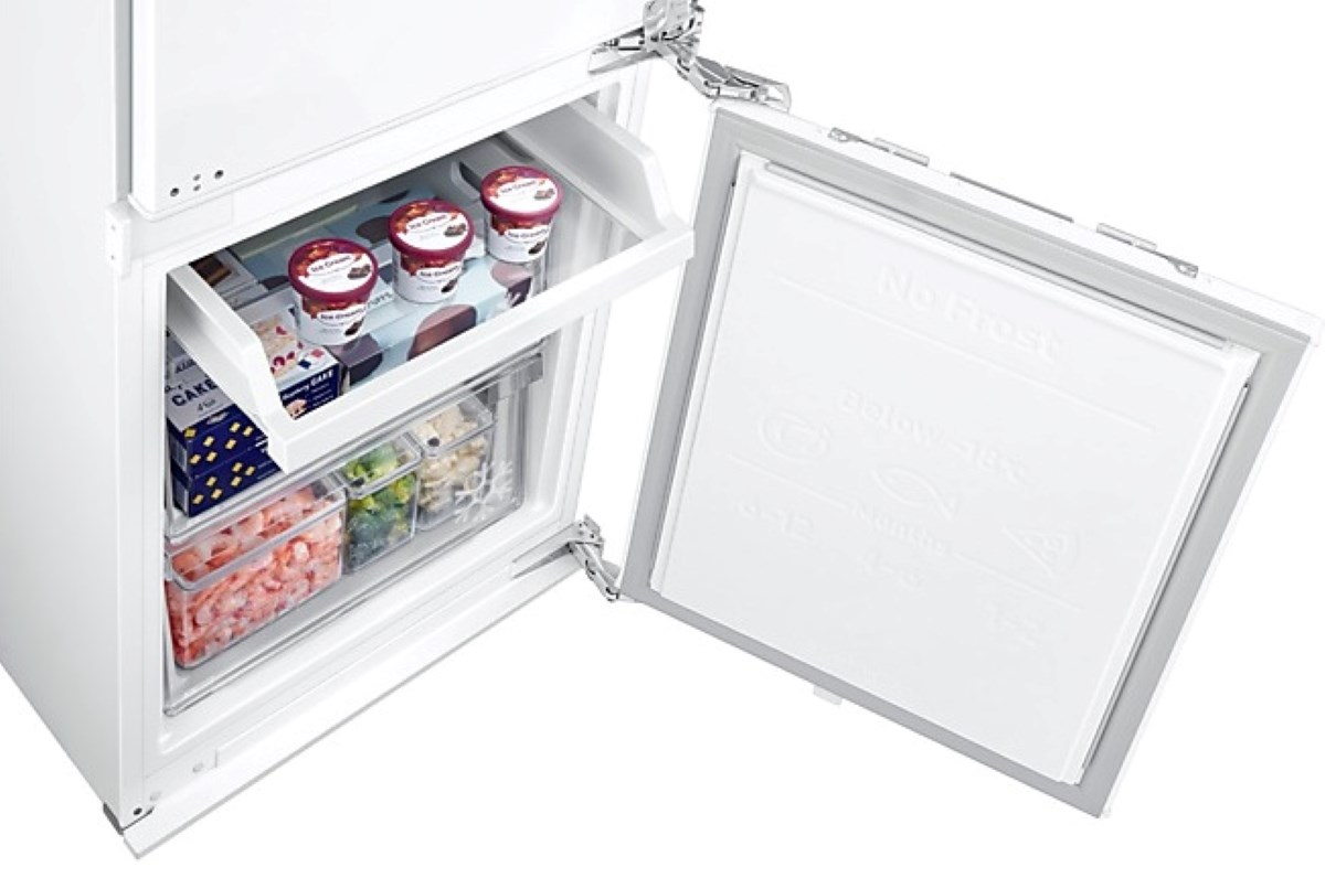 Komora zamrażarki z otwartymi drzwiami, pokazująca szuflady z mrożonkami, w tym lody.