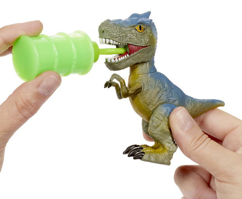Dinosaurier-Spielzeug wird mit grüner Flüssigkeit aus einem Spender gefüttert. Eine Hand hält den Spender.