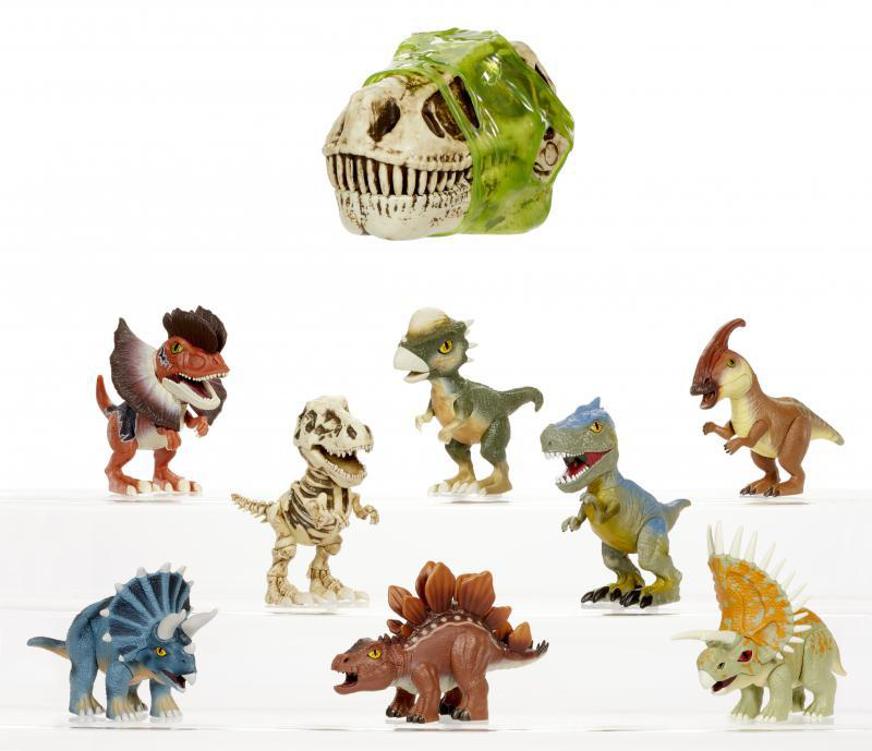 Sammlung von Spielzeugdinosauriern und einem Dinosaurierschädel. Dinosaurier sind in verschiedenen Farben und Arten.