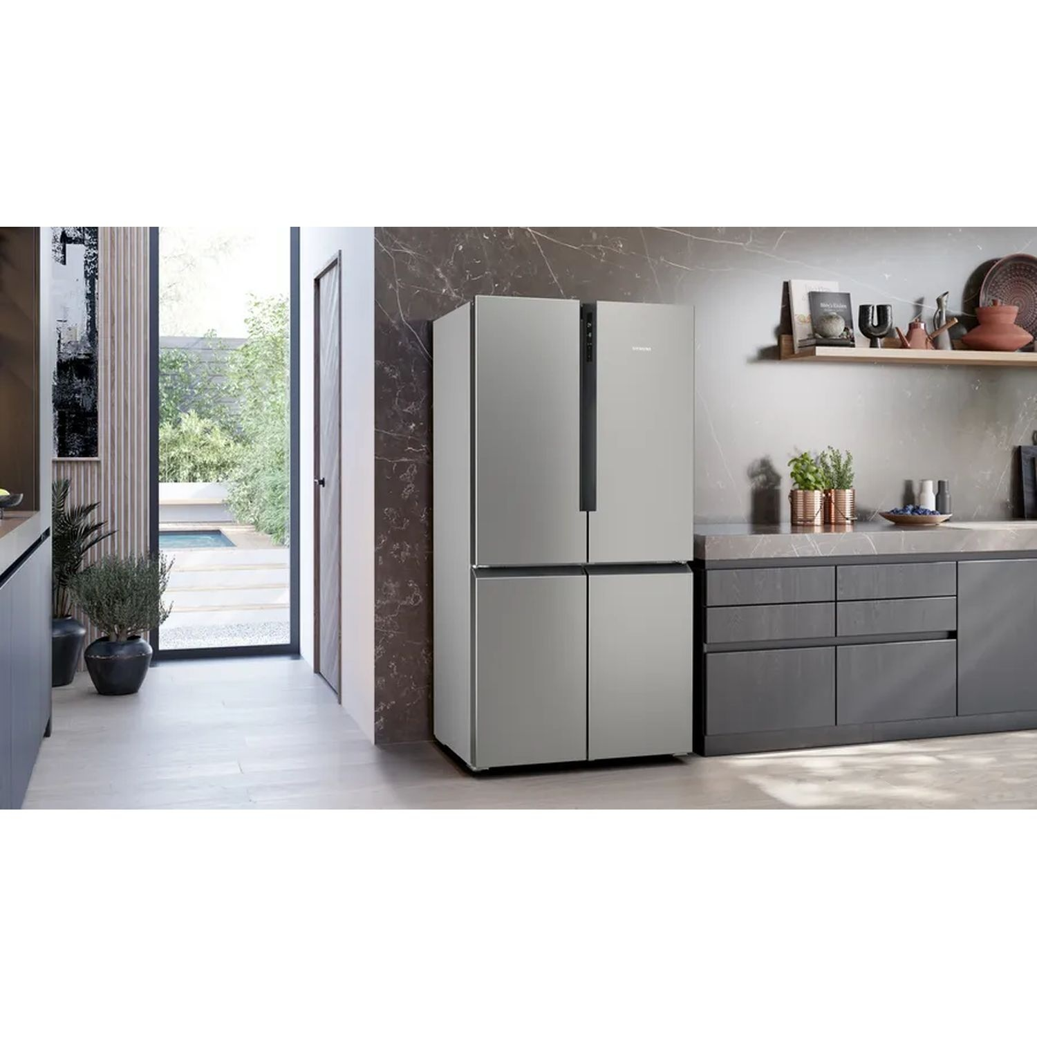 Een zilveren koelkast staat in een moderne keuken met een heldere achtergrond.