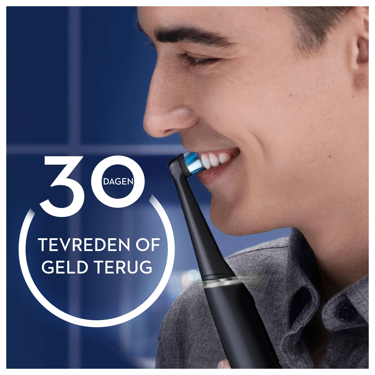 A man smiling while brushing teeth with a black electric toothbrush.
