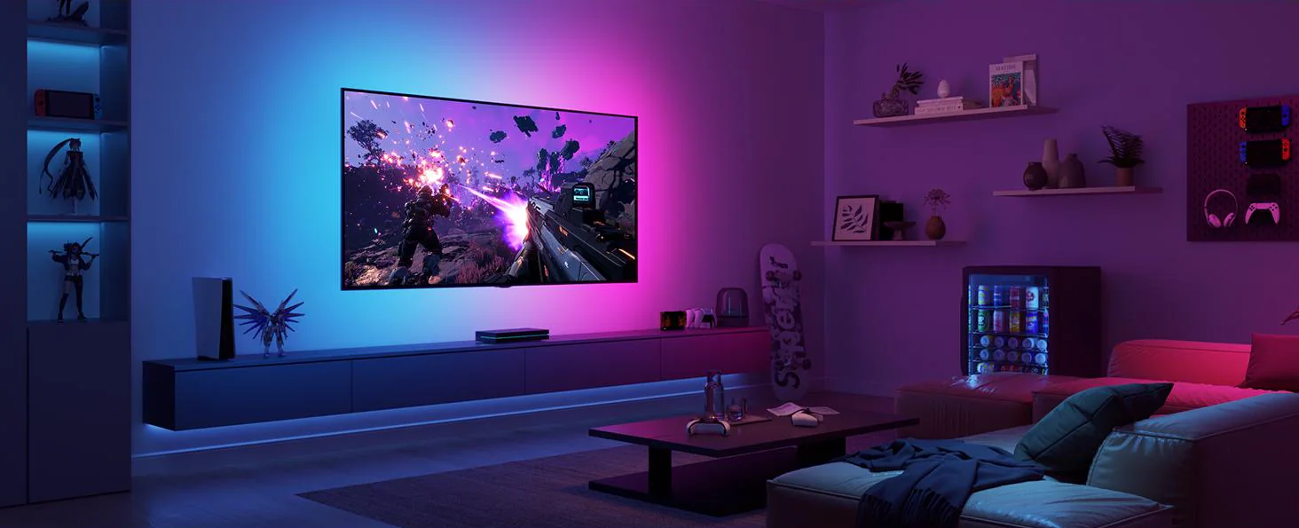 Una stanza con una TV che mostra un gioco, illuminata con luci LED viola e blu.