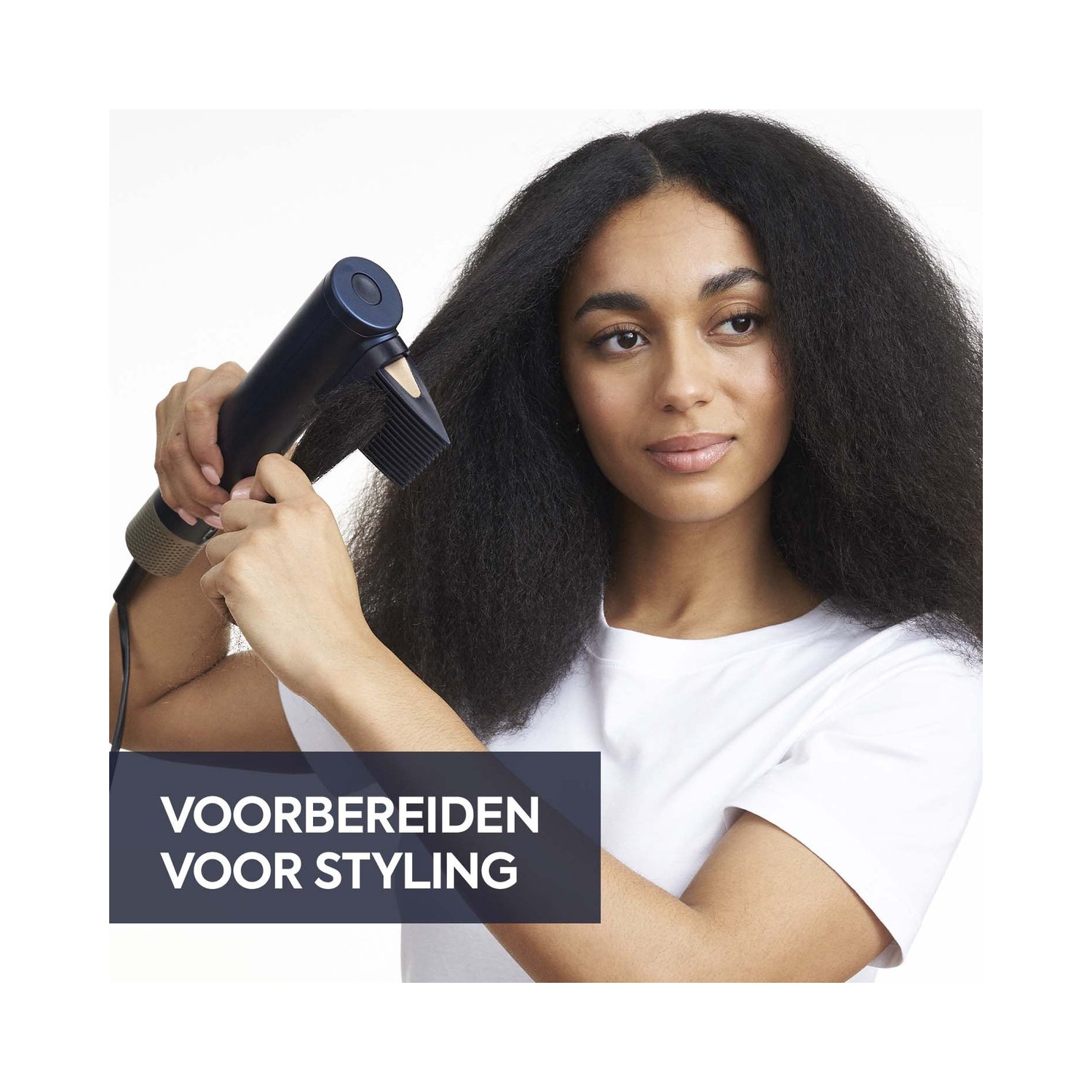 Vrouw die een föhn met kamopzetstuk gebruikt, ter voorbereiding op het stylen.
