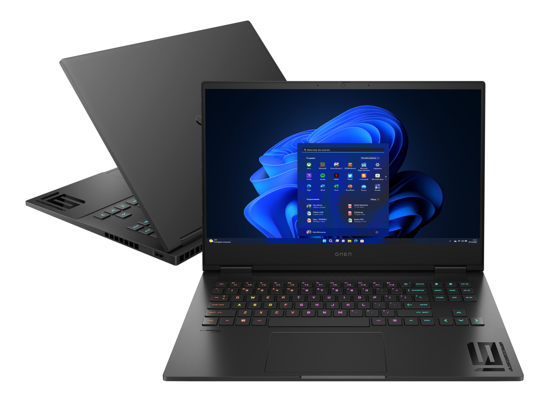 Czarny laptop z wyświetlaczem pokazującym ekran główny systemu Windows, z drugim laptopem w tle.