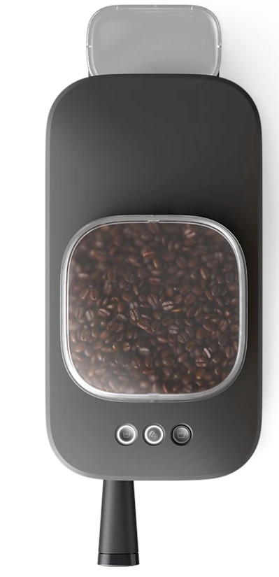 Ekspres do kawy z pojemnikiem na ziarna wypełnionym ziarnami kawy, przyciskami i dyszą.