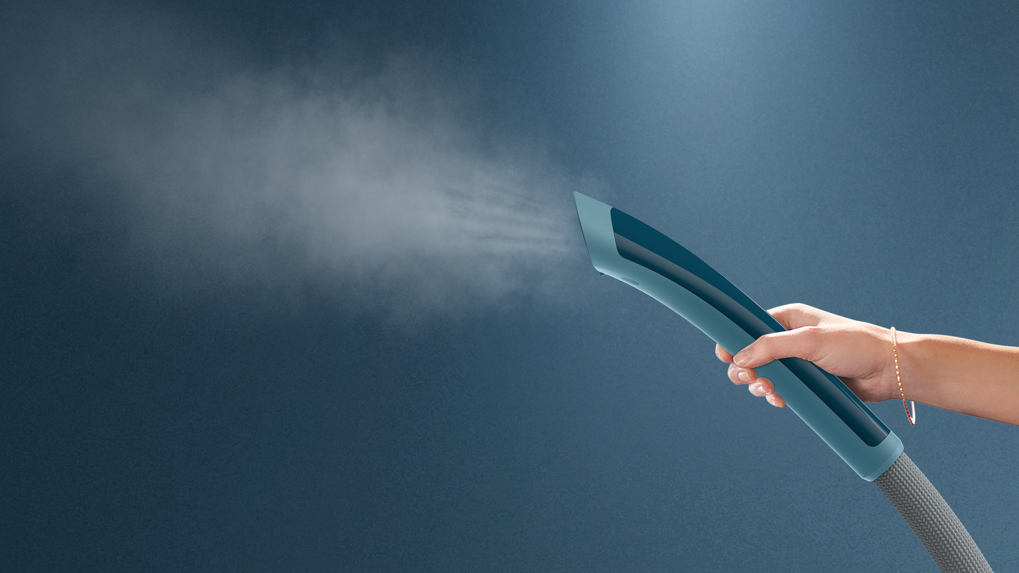 Una mano sostiene un limpiador a vapor azul, liberando vapor contra un fondo azul.