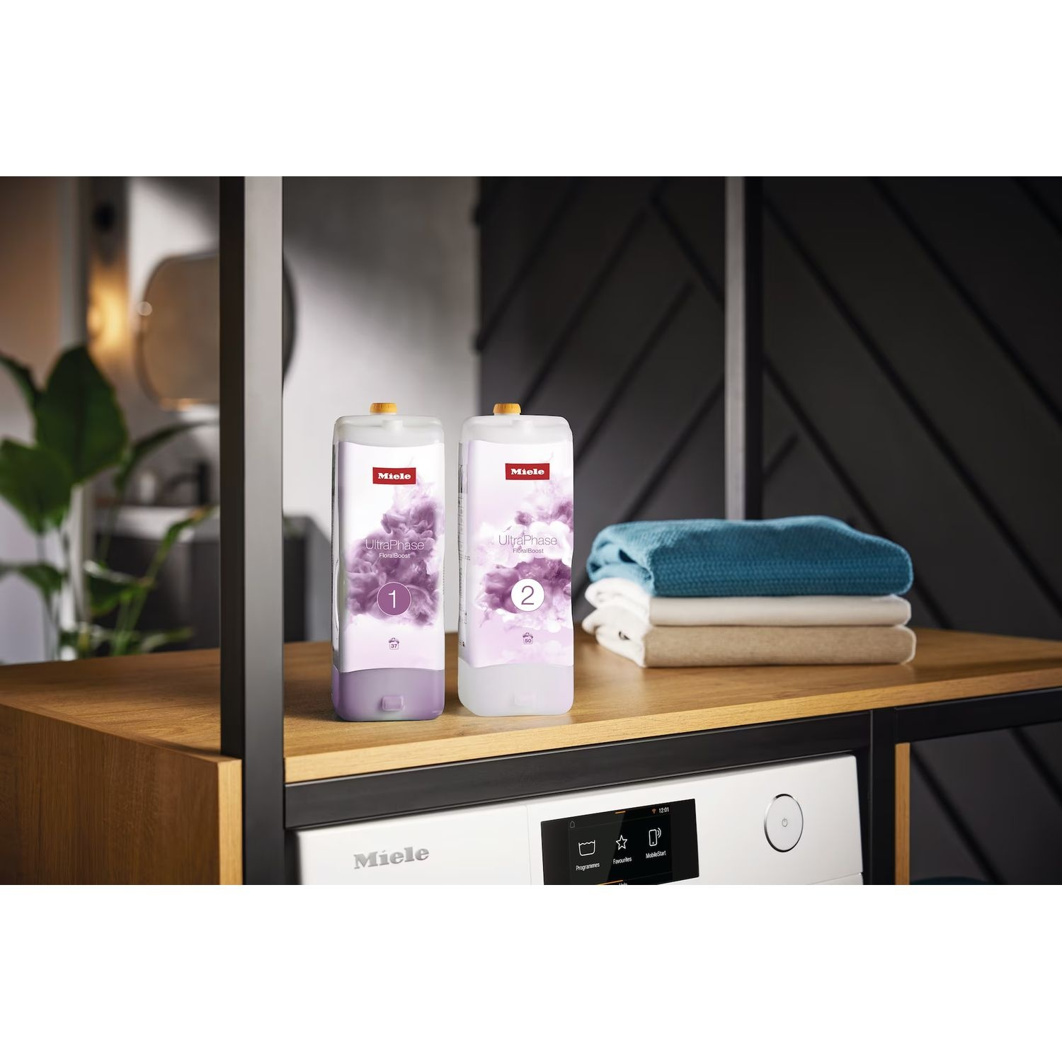 Deux bouteilles de lessive à côté de vêtements pliés.