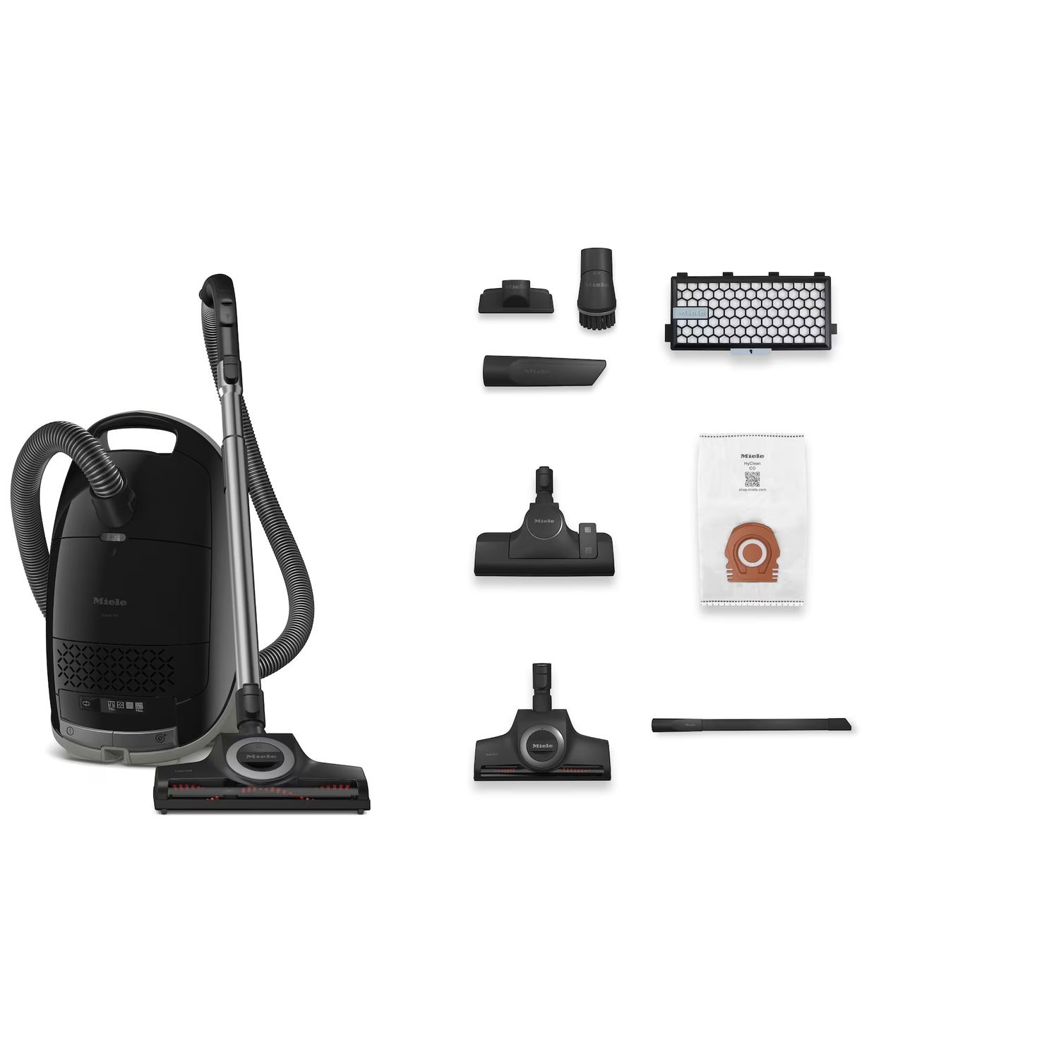 Un aspirateur noir avec accessoires, dont des brosses, et un sac à poussière sur une surface blanche.