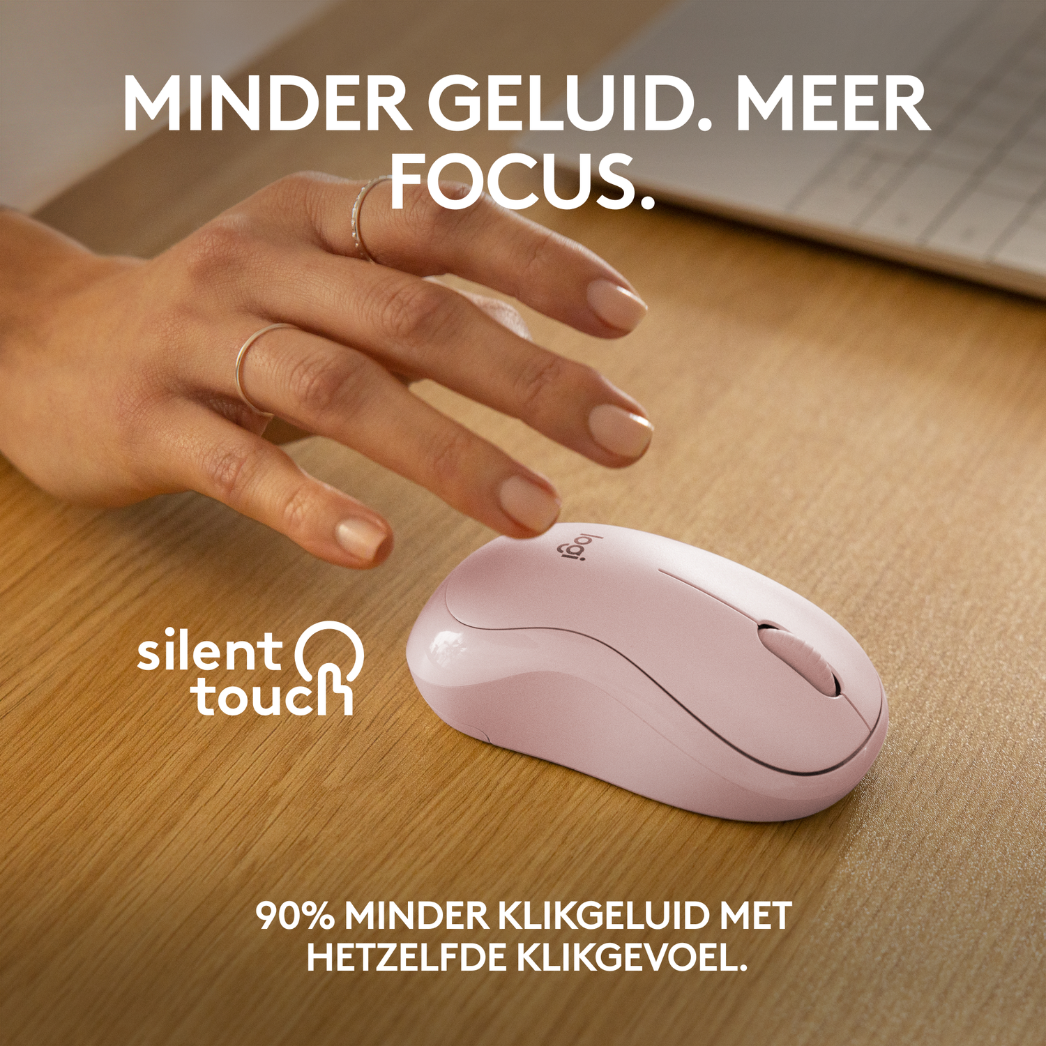 Een hand reikt naar een roze draadloze muis op een houten bureau. Tekst: 'Silent Touch'.