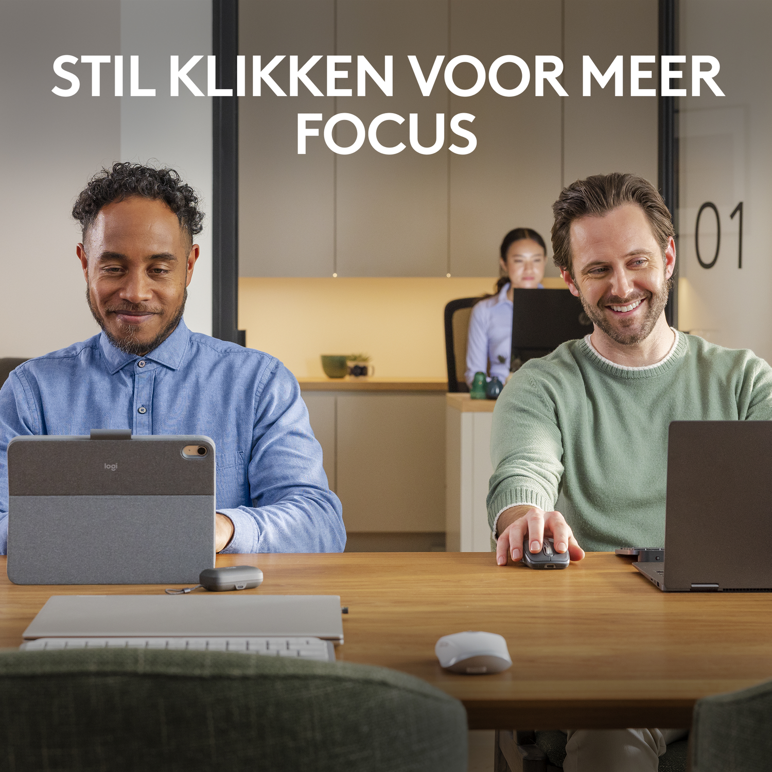 Twee mensen die werken, een met een tablet en een toetsenbord, de ander met een laptop en een muis op het bureau.