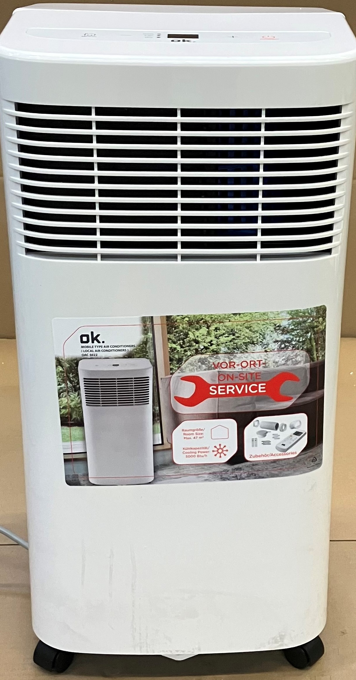 Biały oczyszczacz powietrza z czarnymi otworami wentylacyjnymi i naklejką. Cechy: serwis na miejscu. Biały i czerwony tekst.