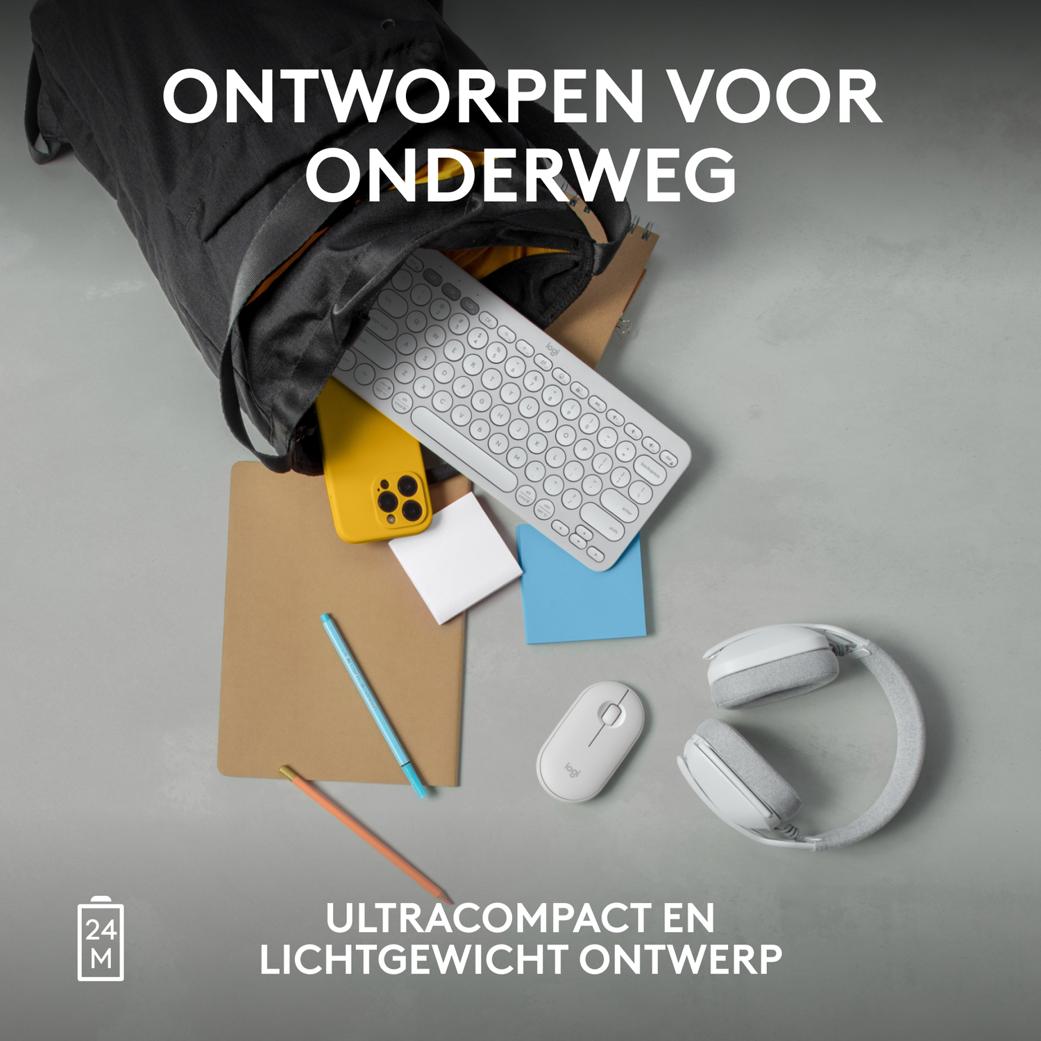A bag with items on a table: keyboard, phone, notepad, pen, mouse, headphones.
