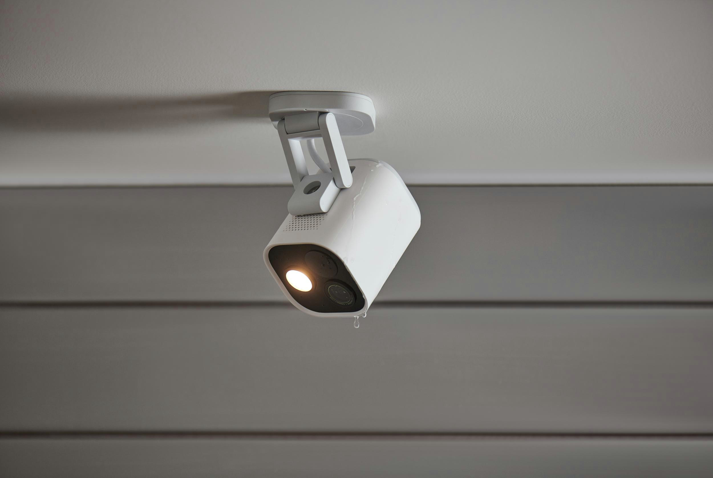 Weiße Überwachungskamera an einer weißen Decke. Die Kamera ist nach unten gerichtet.