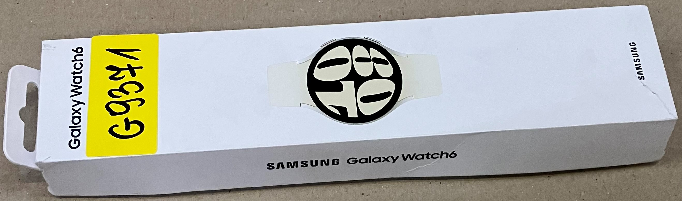 Białe pudełko Samsung Galaxy Watch 6 z żółtą etykietą.