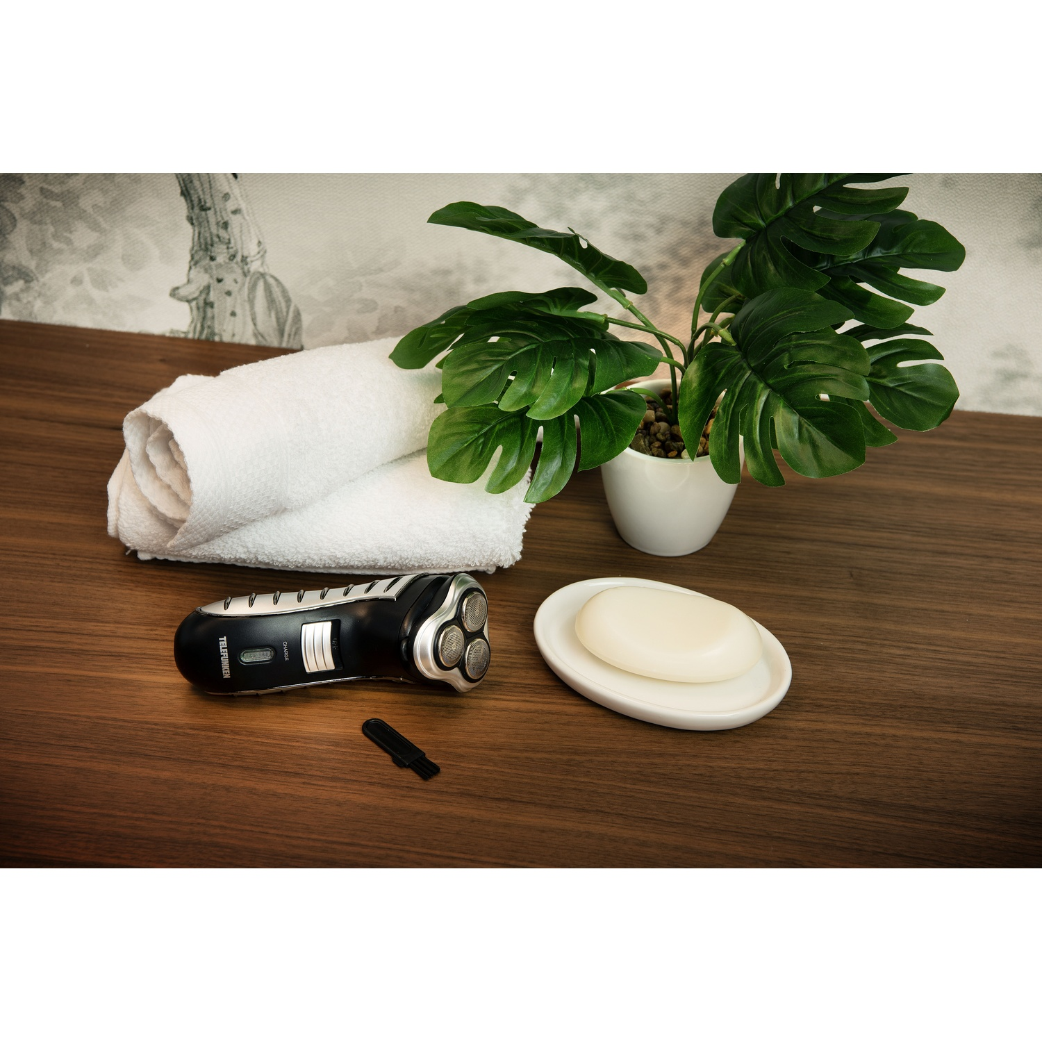 Set da barba su tavolo in legno: rasoio, sapone, spazzola e pianta.