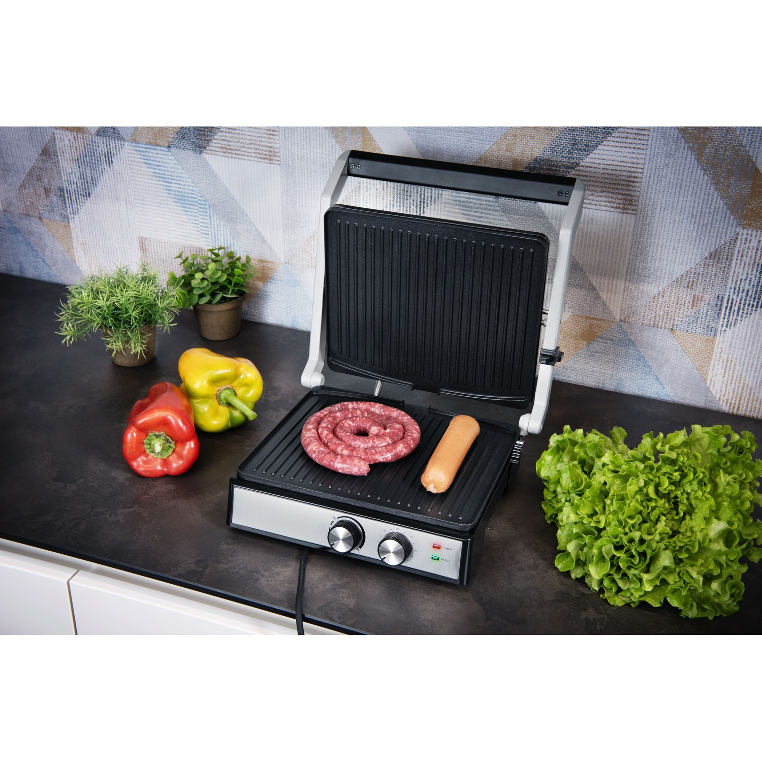 Griglia con salsicce, un hot dog e verdure come peperoni rossi e gialli.