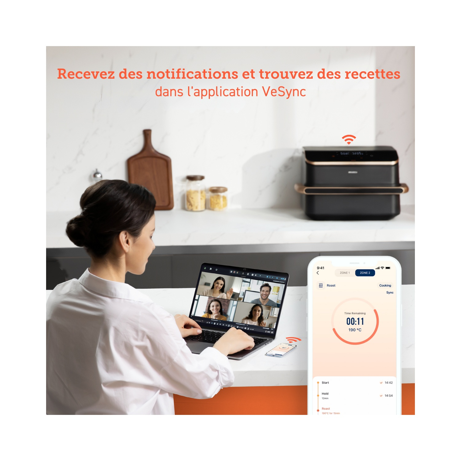 Une femme utilisant un ordinateur portable pour un appel vidéo, avec un four intelligent en arrière-plan.