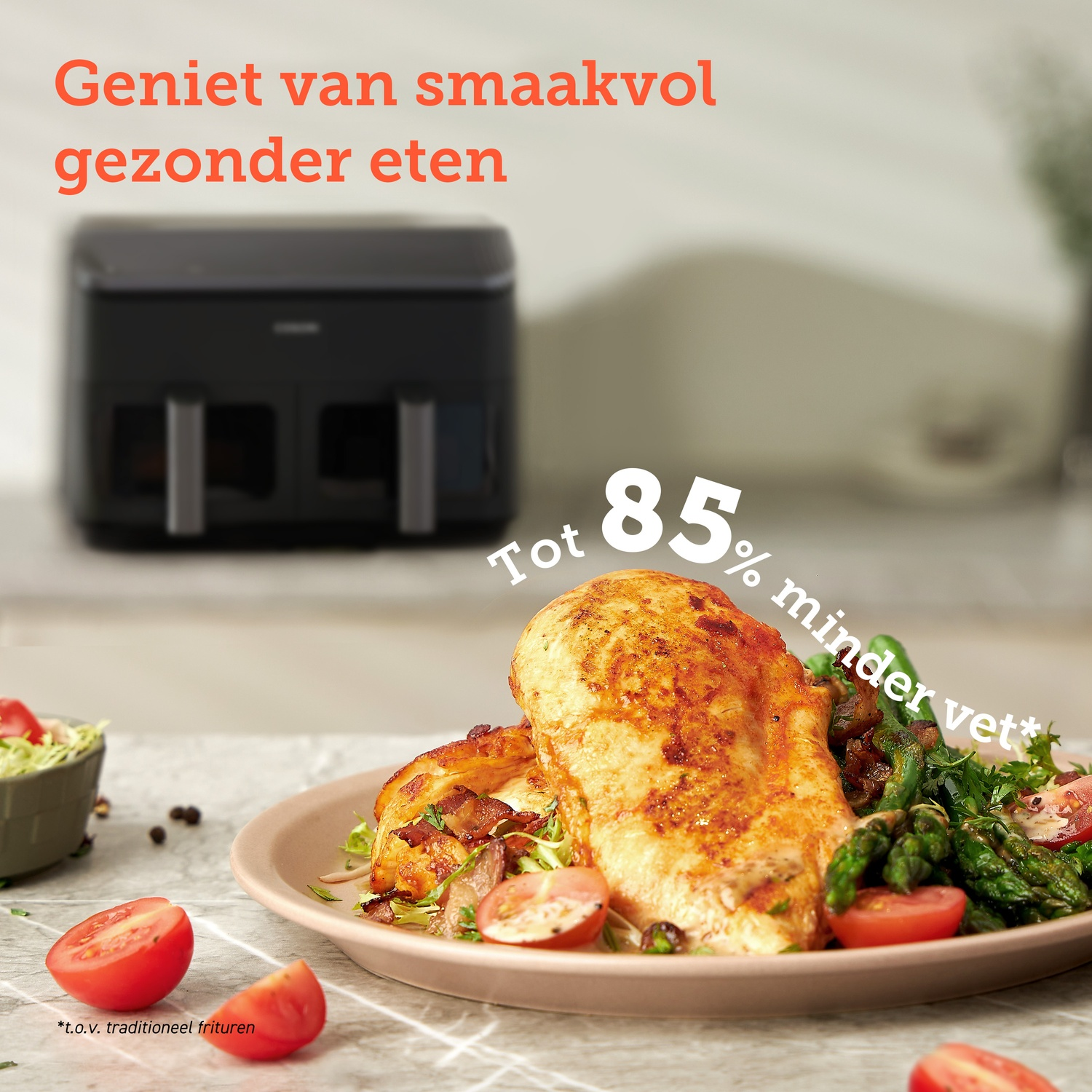 Fried chicken and vegetables on a plate with an air fryer in the background.