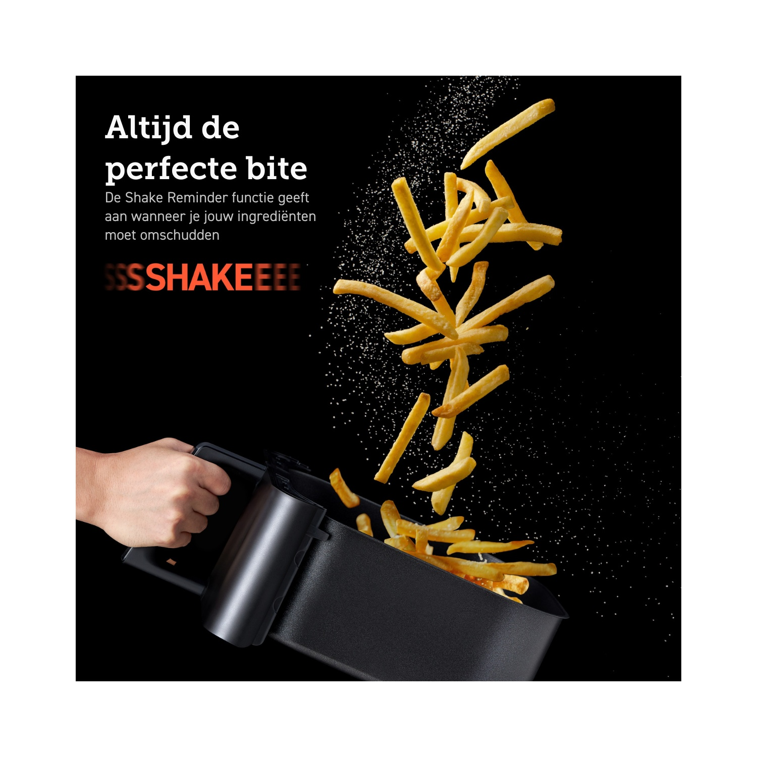 Hand die een zwarte airfryer mand vasthoudt terwijl frietjes op een zwarte achtergrond vallen, met tekst.