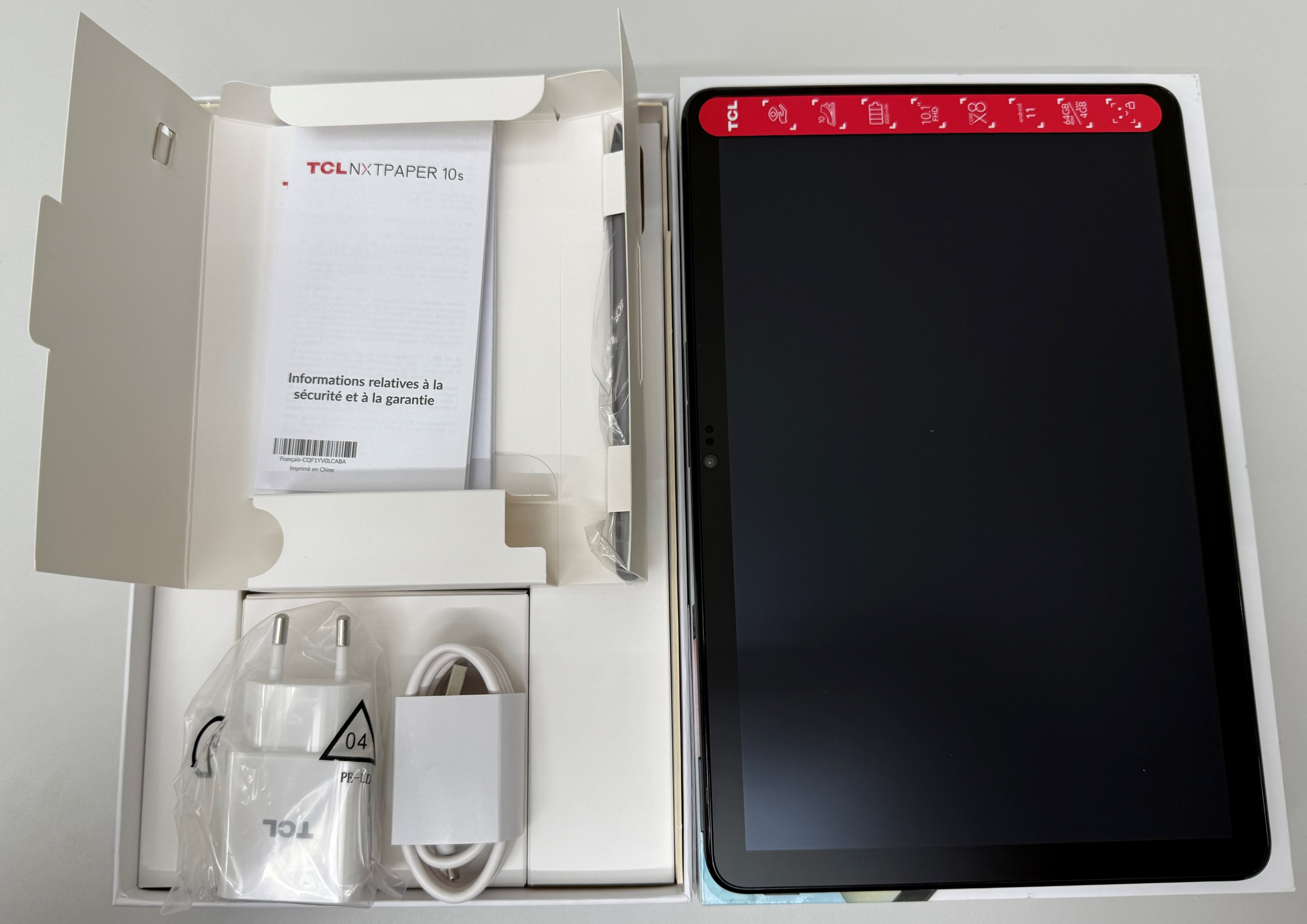 Tablet i akcesoria w otwartym pudełku.