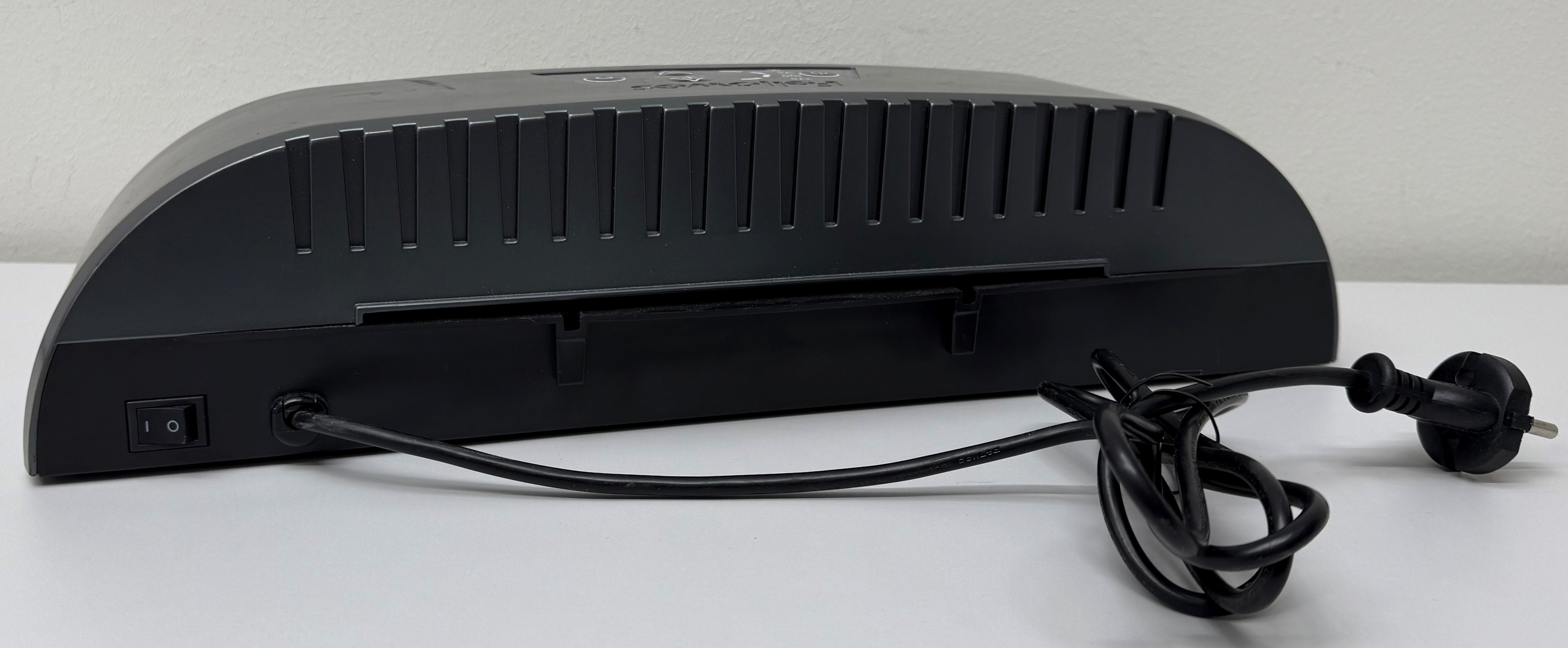 Widok z tyłu czarnej laminarki. Pokazuje włącznik zasilania, przewód zasilający i otwory wentylacyjne.