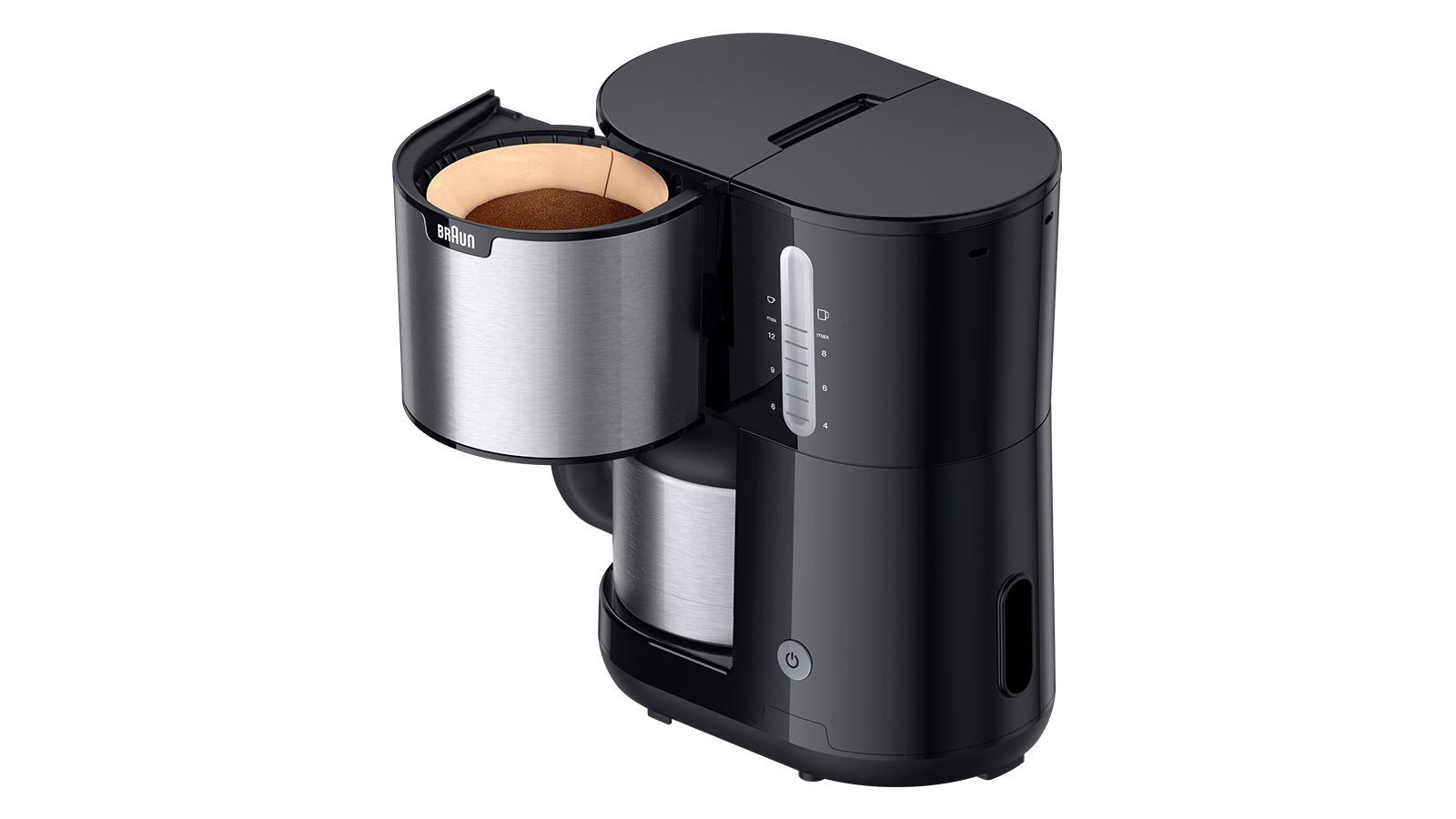 Eine schwarze Kaffeemaschine mit offenem Filterkorb, die Kaffeemehl und eine Wasserstandsanzeige zeigt.