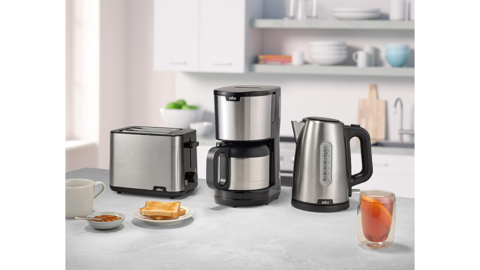 Küchengeräte: Toaster, Kaffeemaschine und Wasserkocher auf einer Arbeitsplatte.