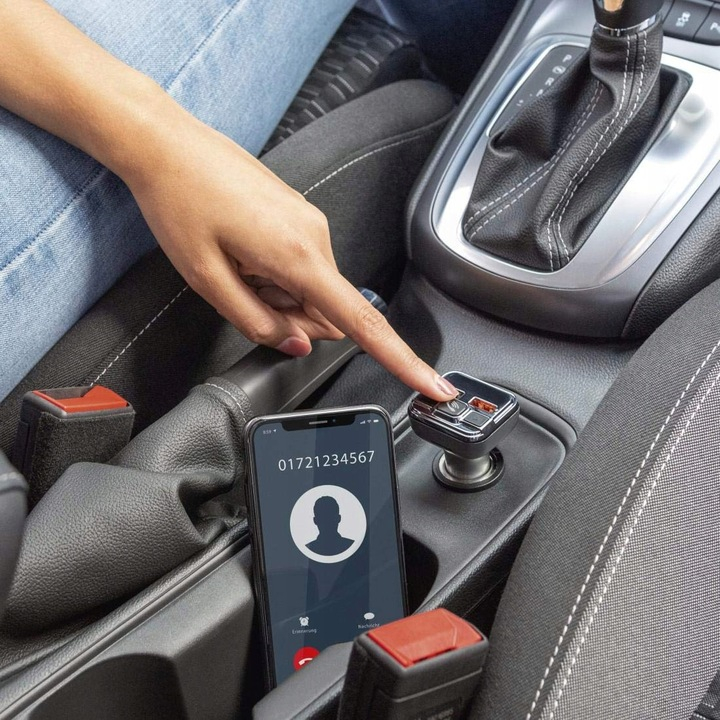 Ręka używająca zestawu samochodowego Bluetooth, z telefonem wyświetlającym połączenie przychodzące.