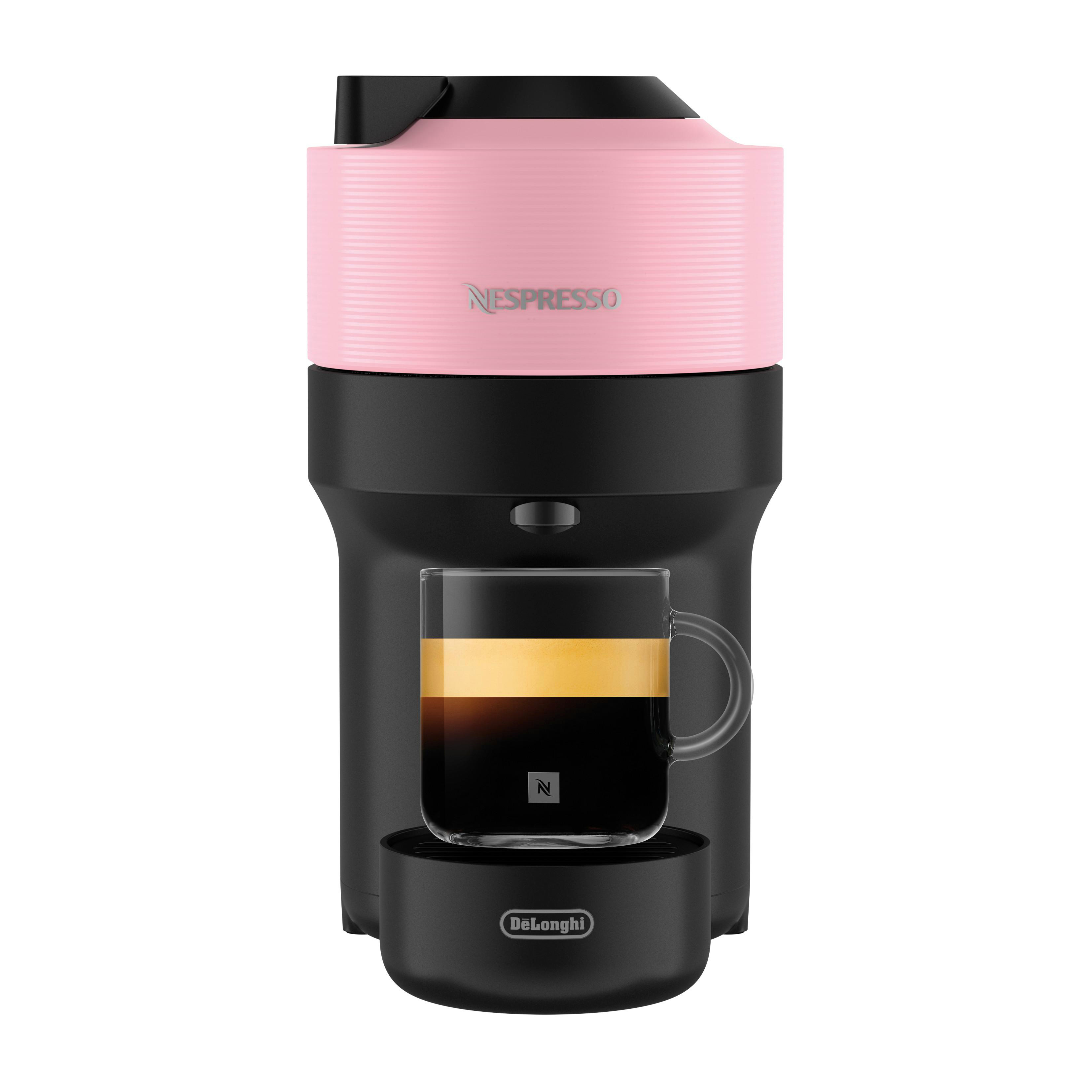 Rosa und schwarze Nespresso-Kaffeemaschine. Glasbecher mit Kaffee, schwarzer Sockel.