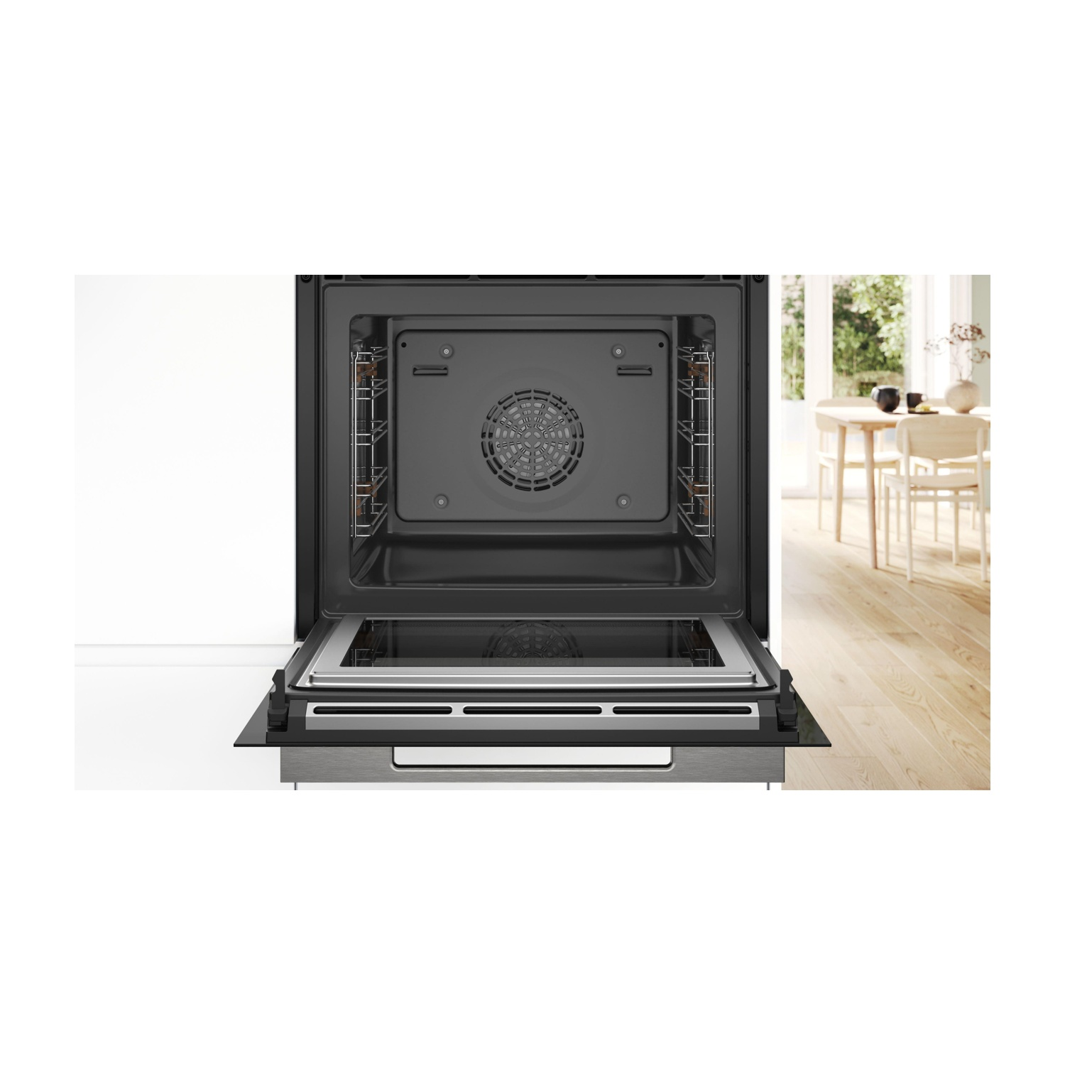 Forno aperto con interno e porta visibili, pareti bianche e sala da pranzo sullo sfondo.
