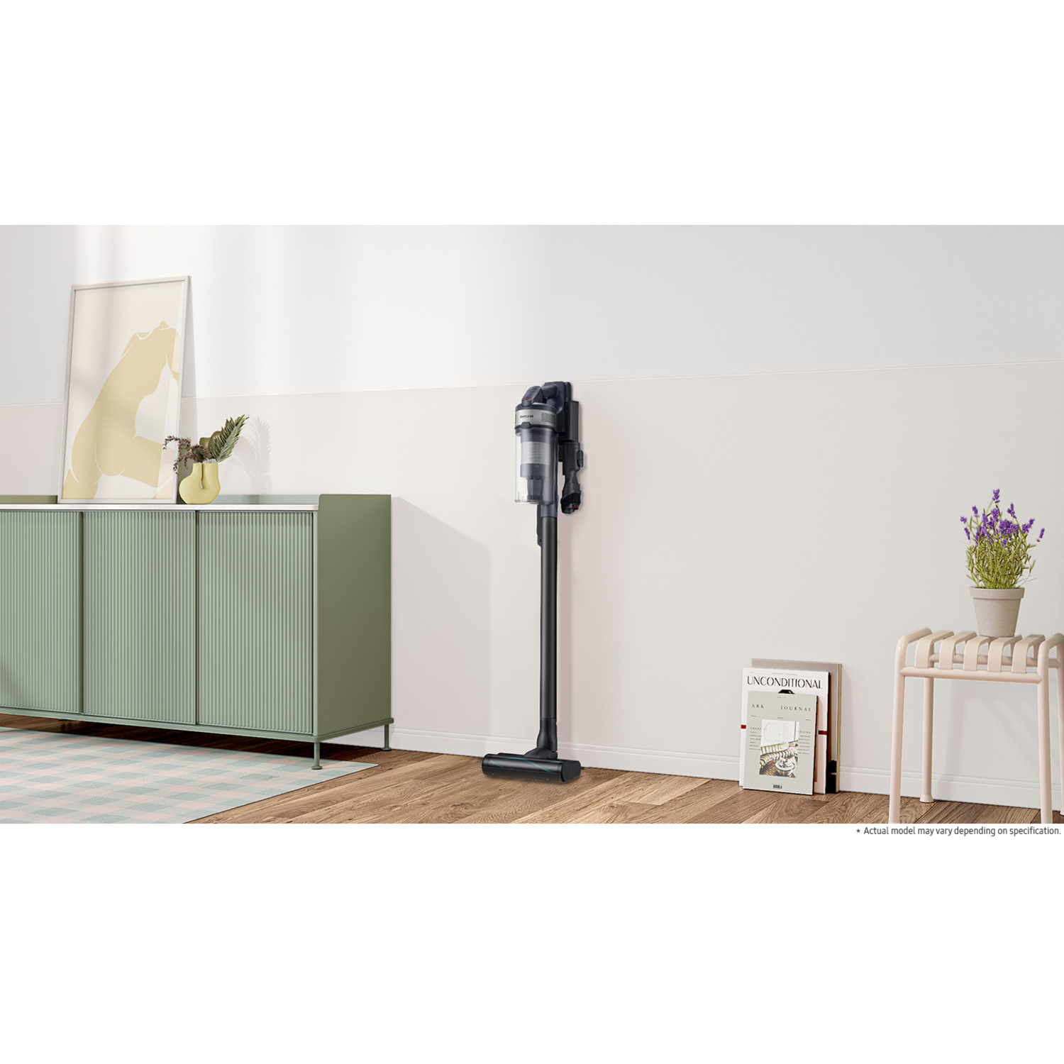 Un aspirateur noir debout. Il est à côté d'un meuble.