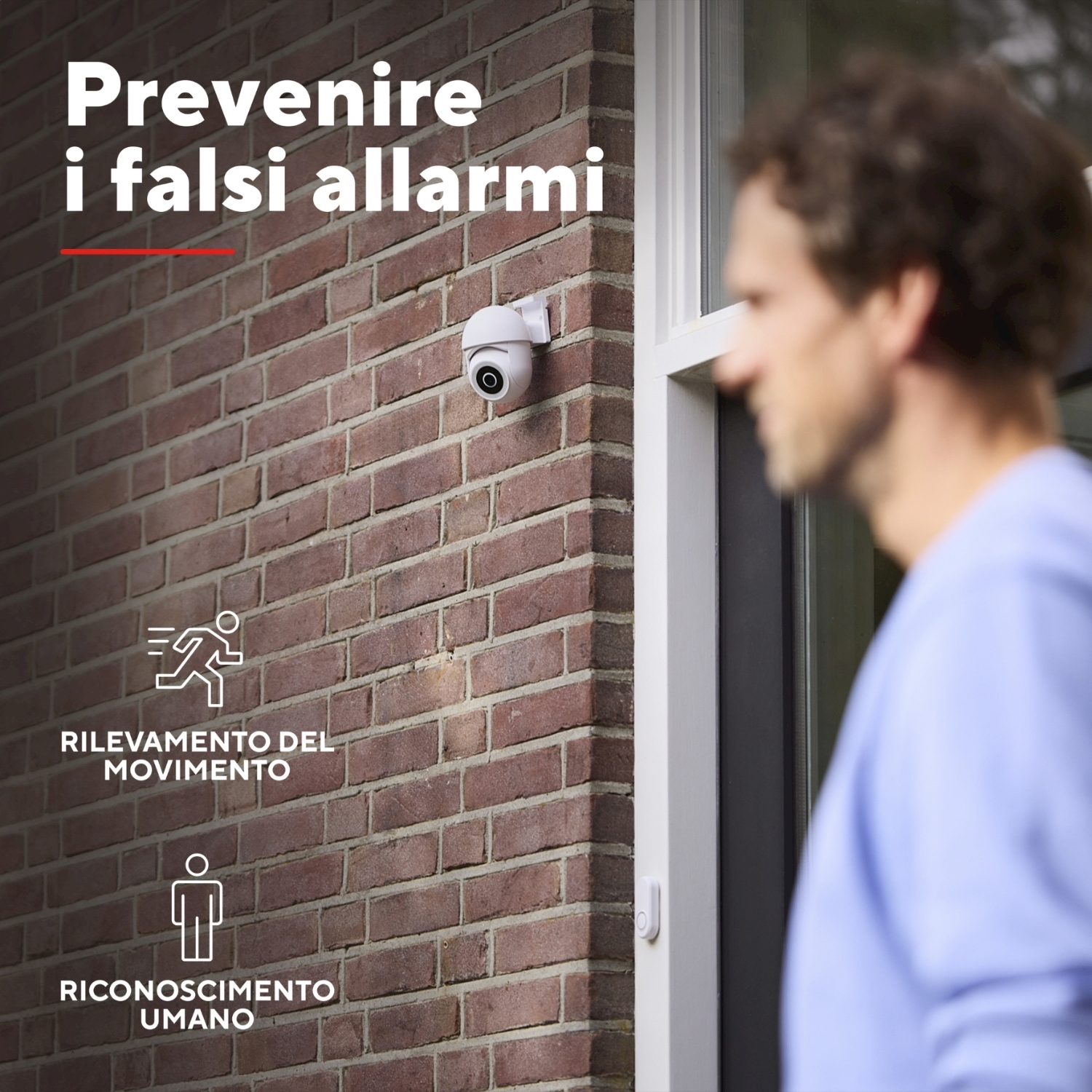 Telecamera di sicurezza su un muro di mattoni. Testo: "Prevenire falsi allarmi". Uomo sullo sfondo.