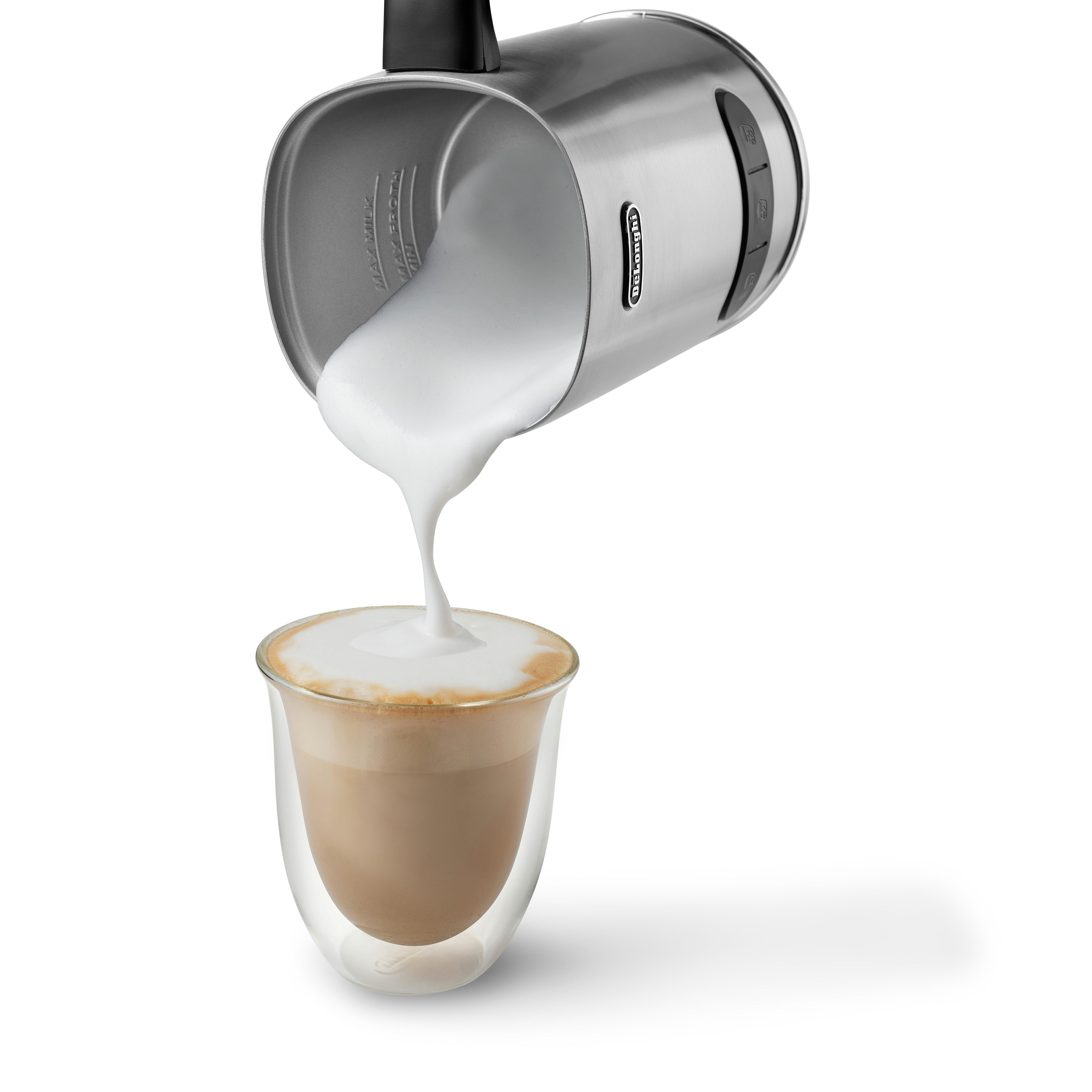 Silberner Milchaufschäumer gießt weißen Schaum in ein Glas Kaffee.