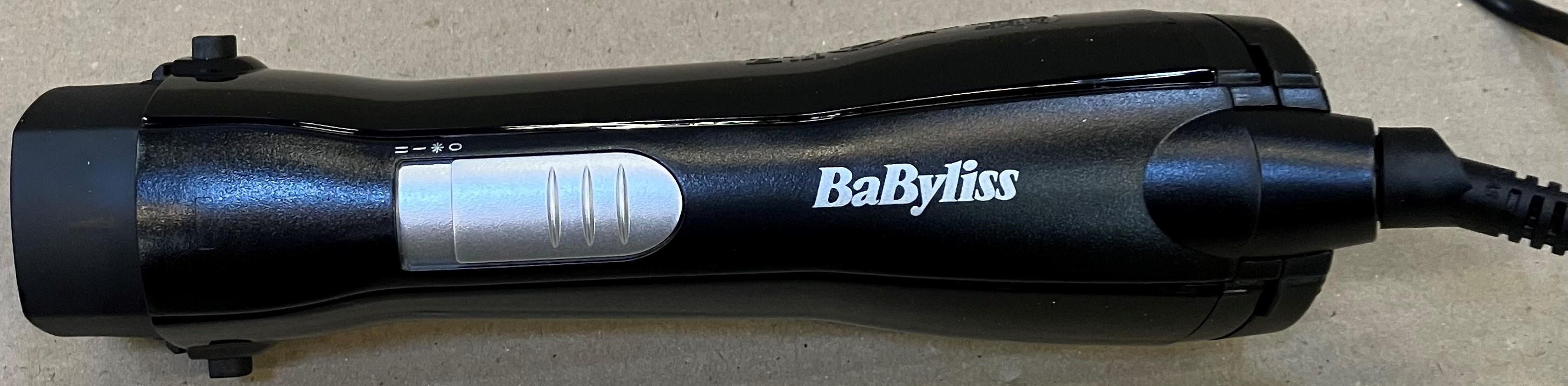 Czarna prostownica BaByliss ze srebrnym przełącznikiem i kablem.