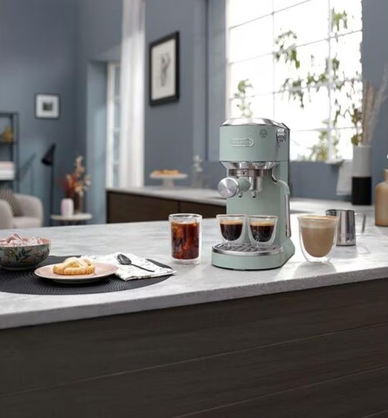 Eine Küchentheke mit einer mintgrünen Espressomaschine und Getränken.