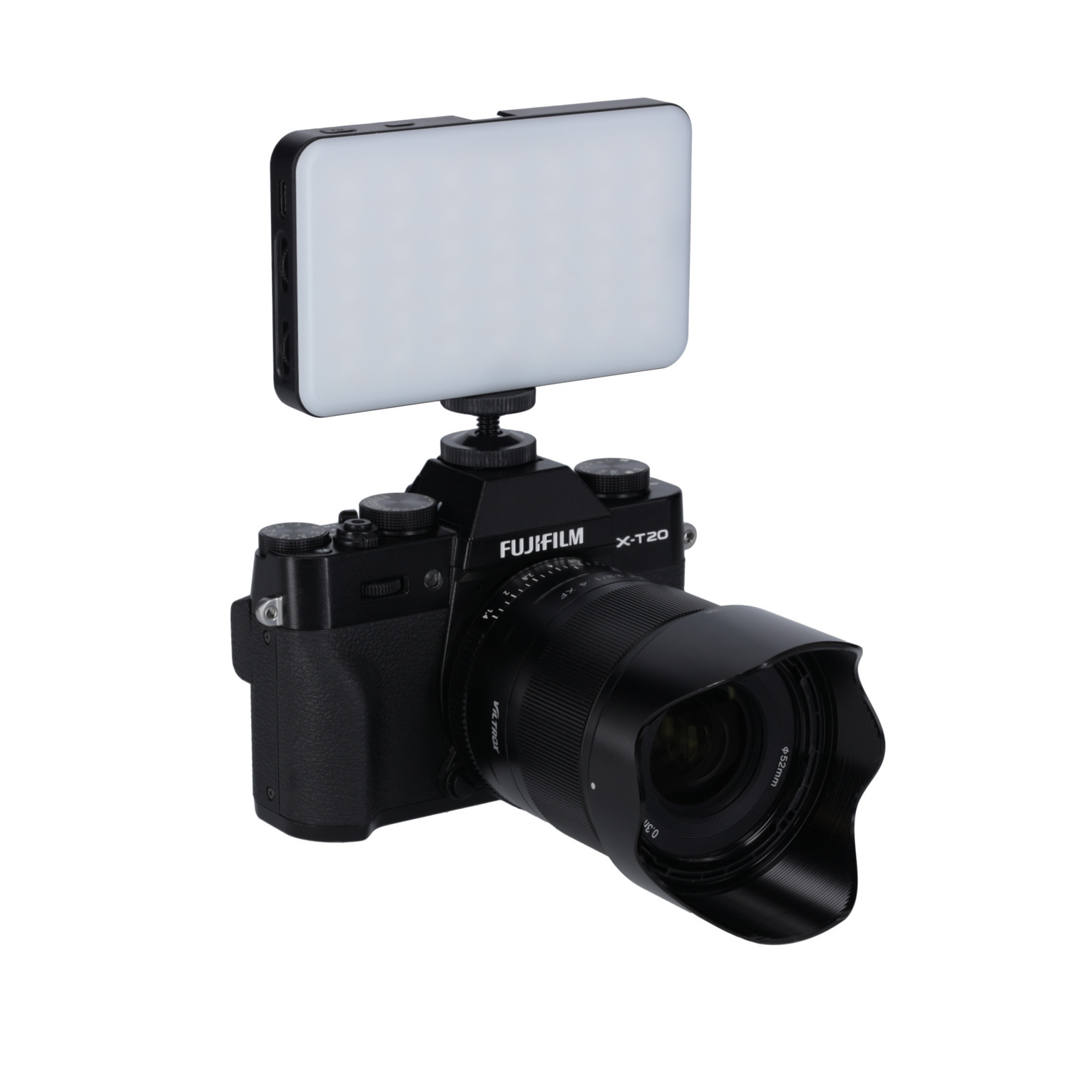 Black camera with a lens and a light attached. It is on a white background.