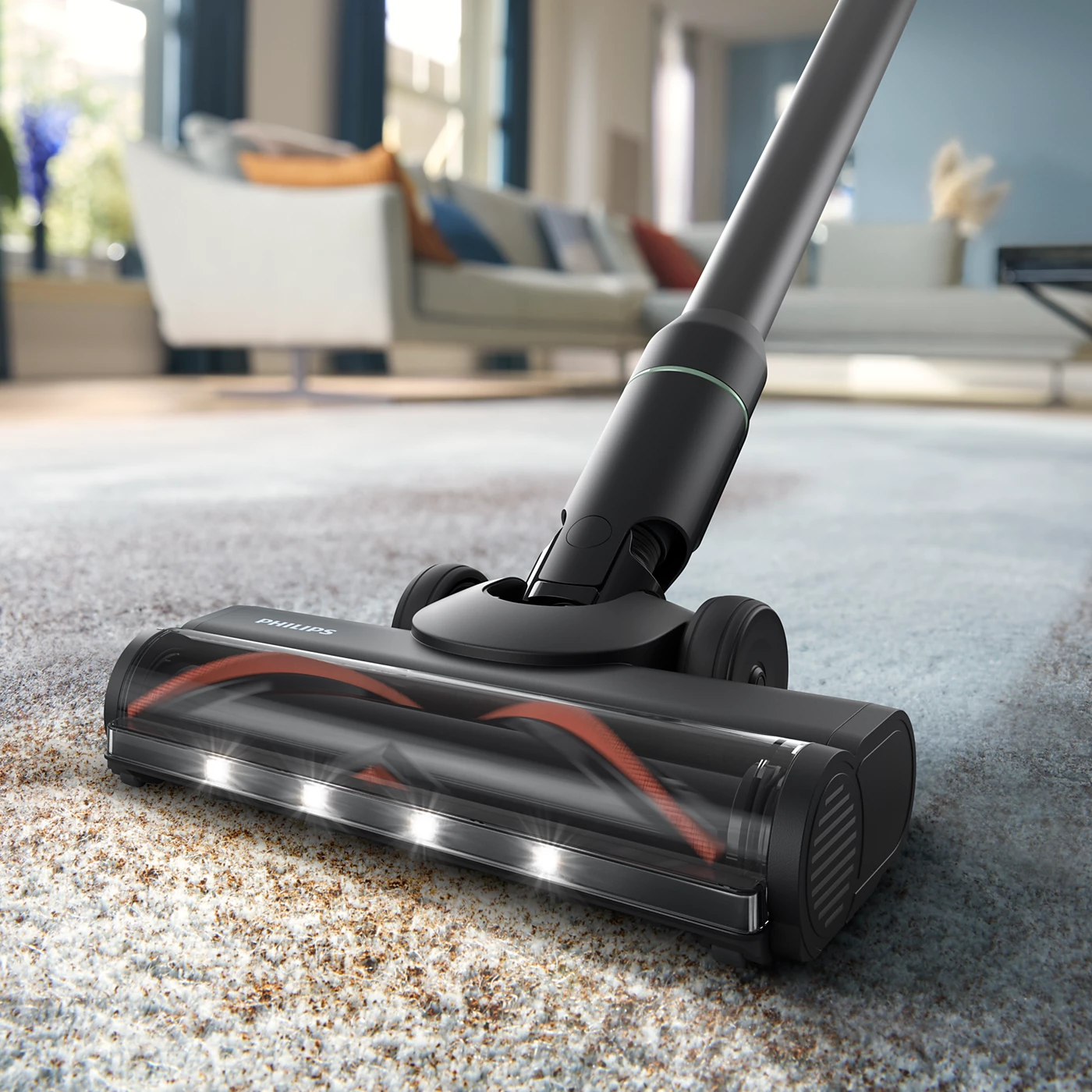 Tête d'aspirateur noire avec brosse rouge et lumières sur un tapis.