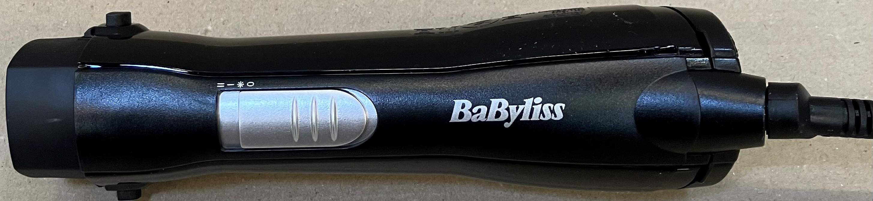 Czarna suszarka do włosów BaByliss z srebrnym przełącznikiem i kablem.