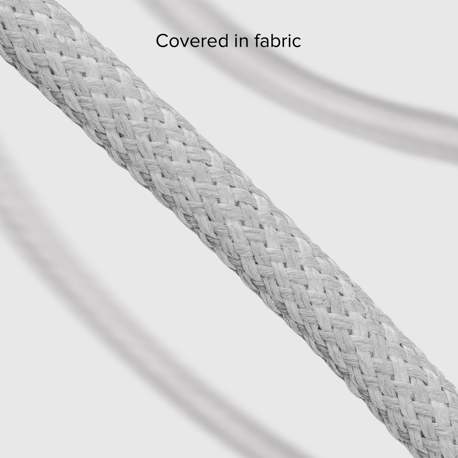Close up of white fabric covered cable with clear blur background. Focus on the cable's texture.